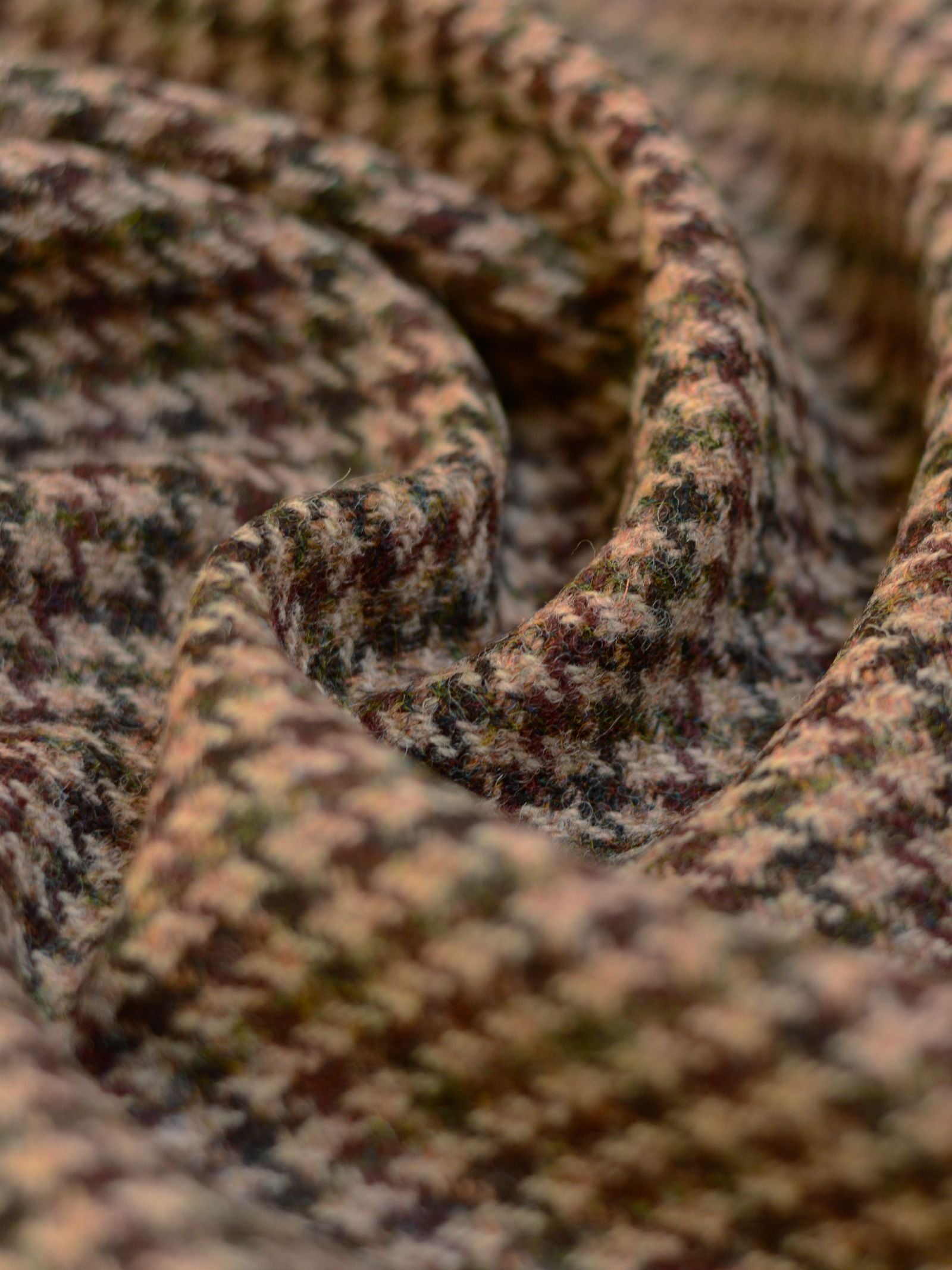 Close-up of Harris Tweed 93904 by Campbell's of Beauly, showing its soft brown and beige houndstooth pattern, gently folded to highlight the classic Scottish fabric’s texture and timeless style.