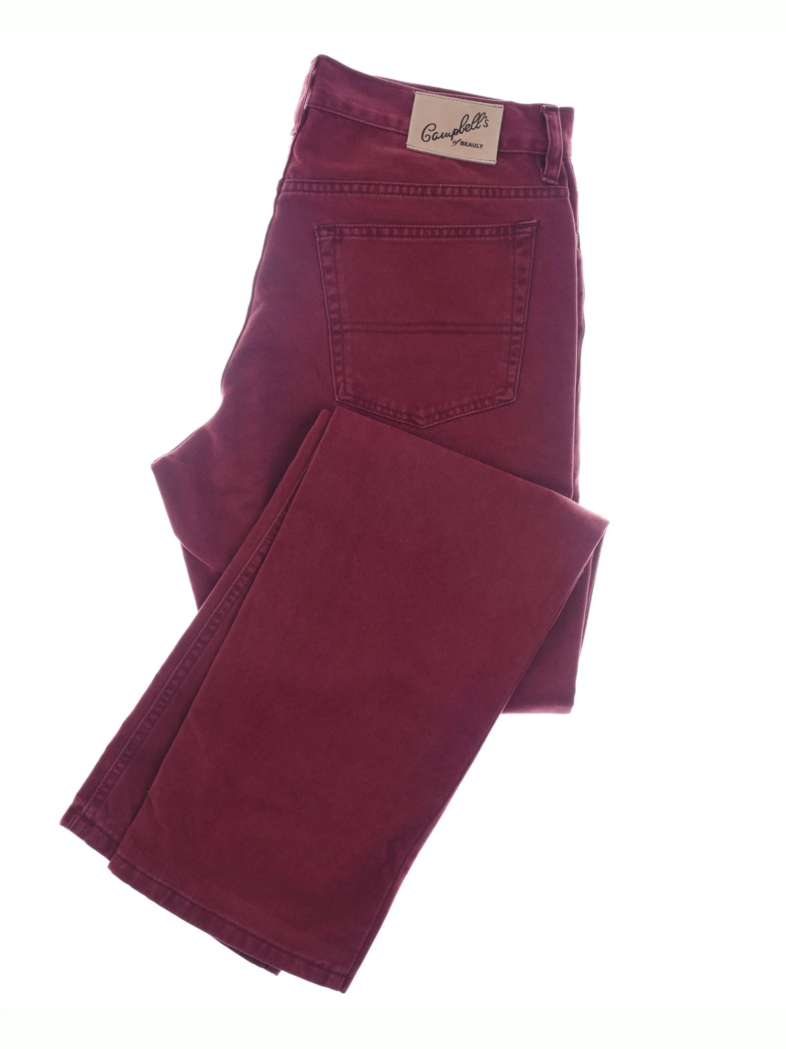 A pair of folded maroon Colour Cotton Jeans by Campbell's of Beauly, featuring straight legs, a visible back pocket, and a white waistband label, displayed on a white background.