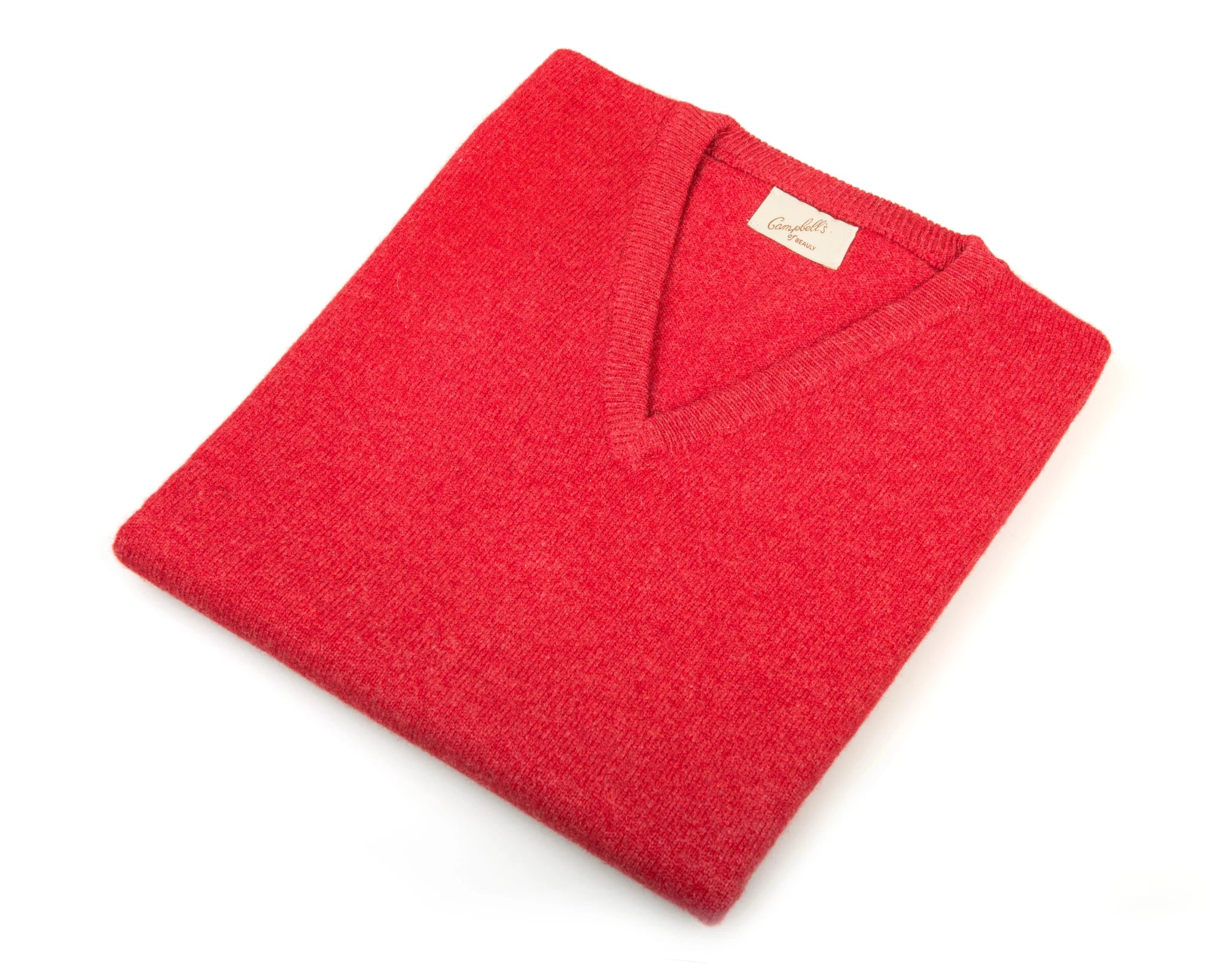 The Campbell's of Beauly Auld Stock Lambswool V-Neck Jumper in classic red is neatly folded on a white background, showcasing its beige neckline label.