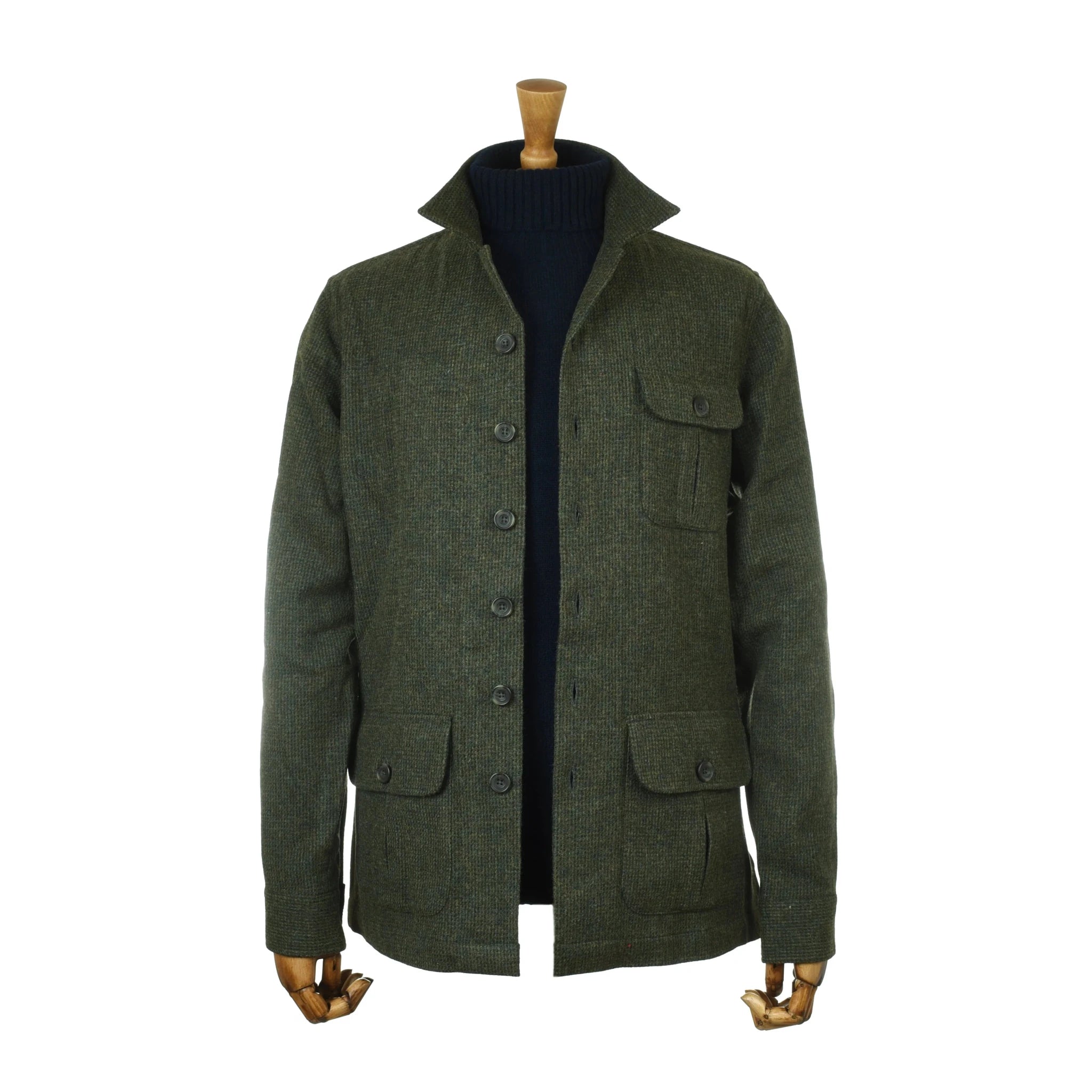 A mannequin showcases the Auld Stock Casual Shacket by Campbell’s of Beauly—a dark green, button-up wool shacket inspired by British tweed, featuring four front pockets and a high collar—layered effortlessly over a black turtleneck sweater for a relaxed tailoring look.