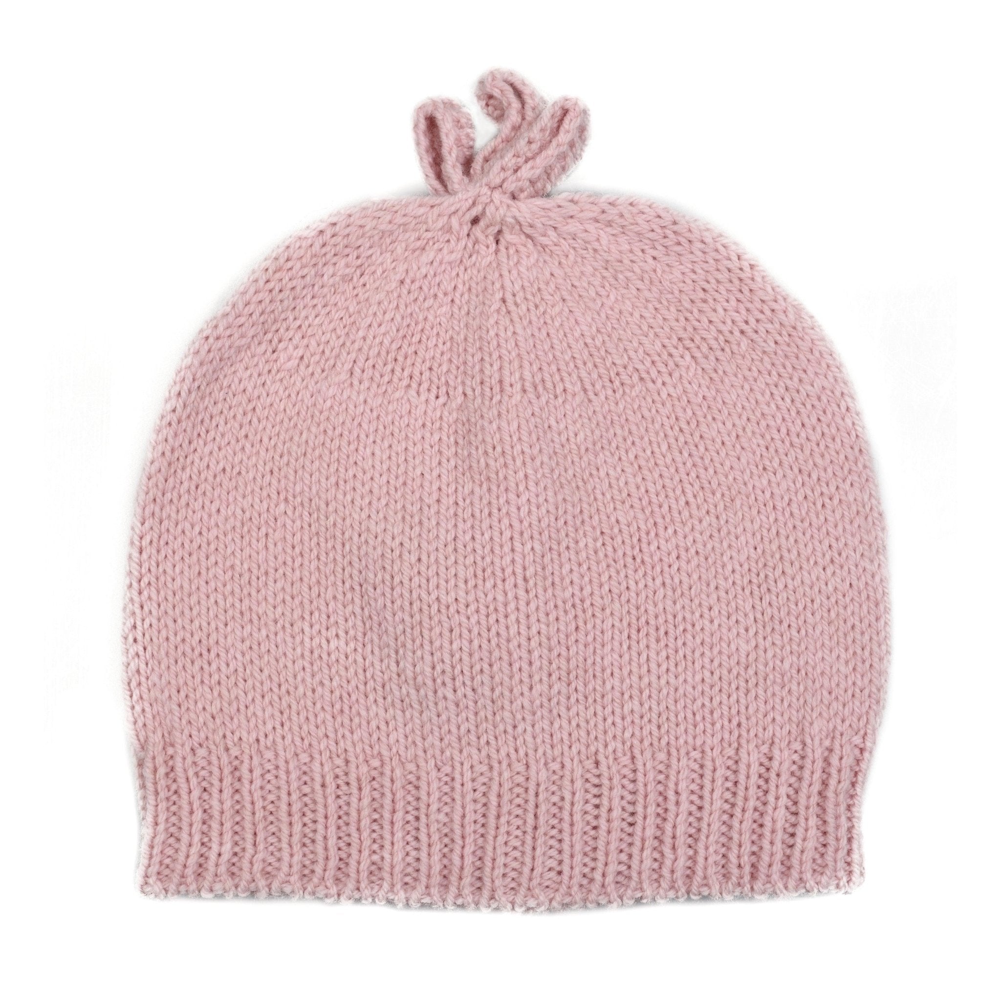 The Campbell's of Beauly Baby Lambswool Bonnet is a soft, light pink hand-knitted beanie featuring a ribbed edge and two small top loops, shown on a white background.
