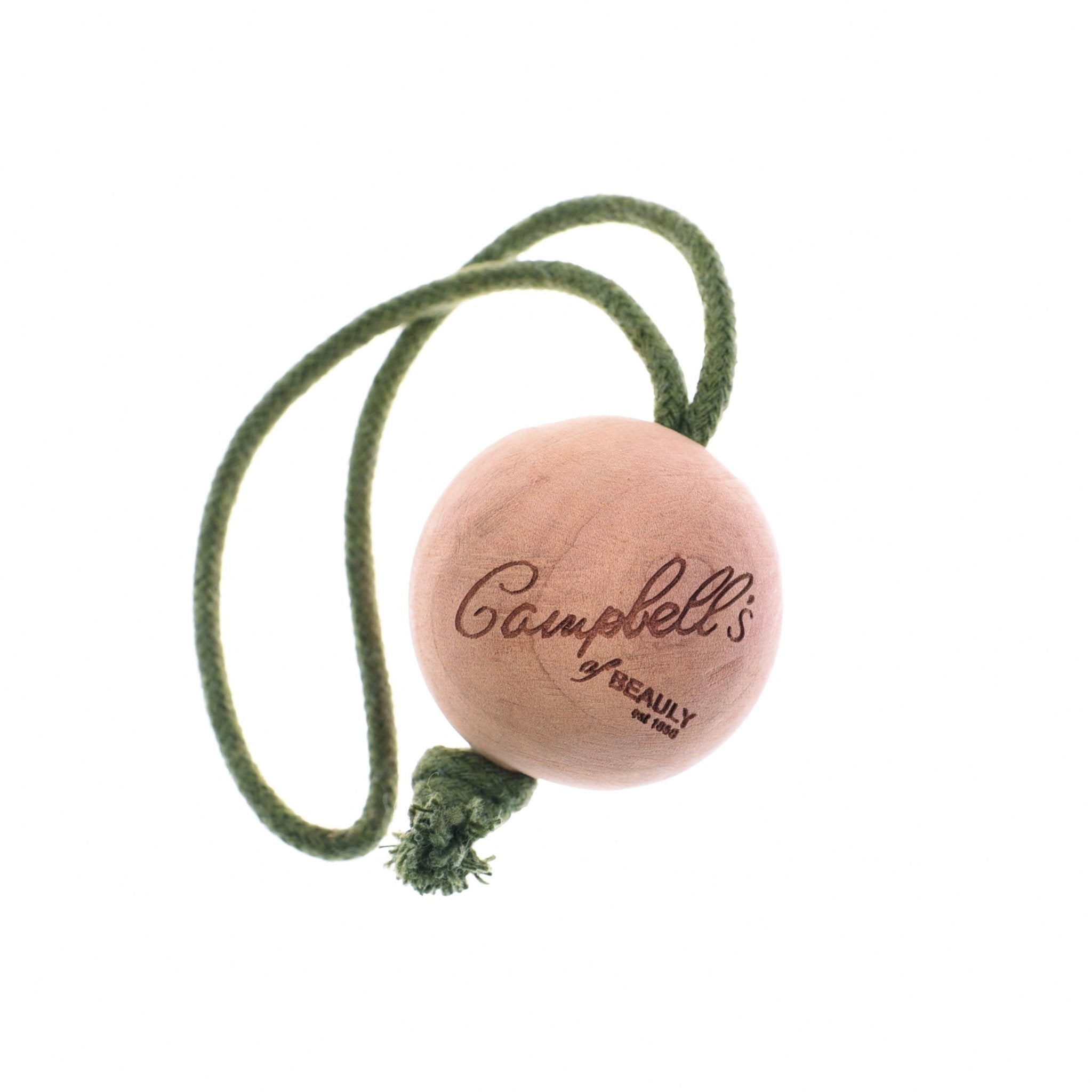 The Cedar Ball by Campbells of Beauly, engraved with the brand name and attached to a green braided cord, acts as an elegant moth deterrent to keep your clothing fresh. Pictured against a white background.