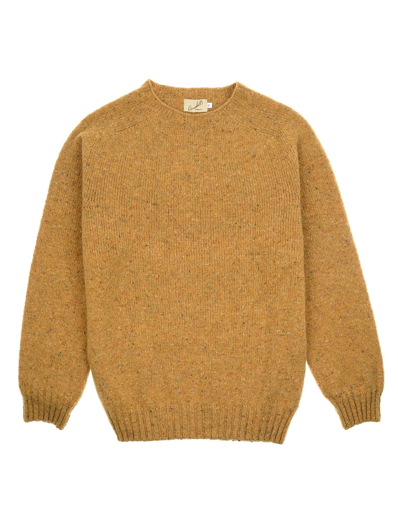 A mustard yellow knit sweater, crafted from soft lambswool, with long sleeves, ribbed cuffs and hem, and a classic crew neckline, laid flat on a white background. This Donegal Lambswool Crew Neck Jumper by Campbell’s of Beauly is expertly made in Scotland for timeless style and quality.