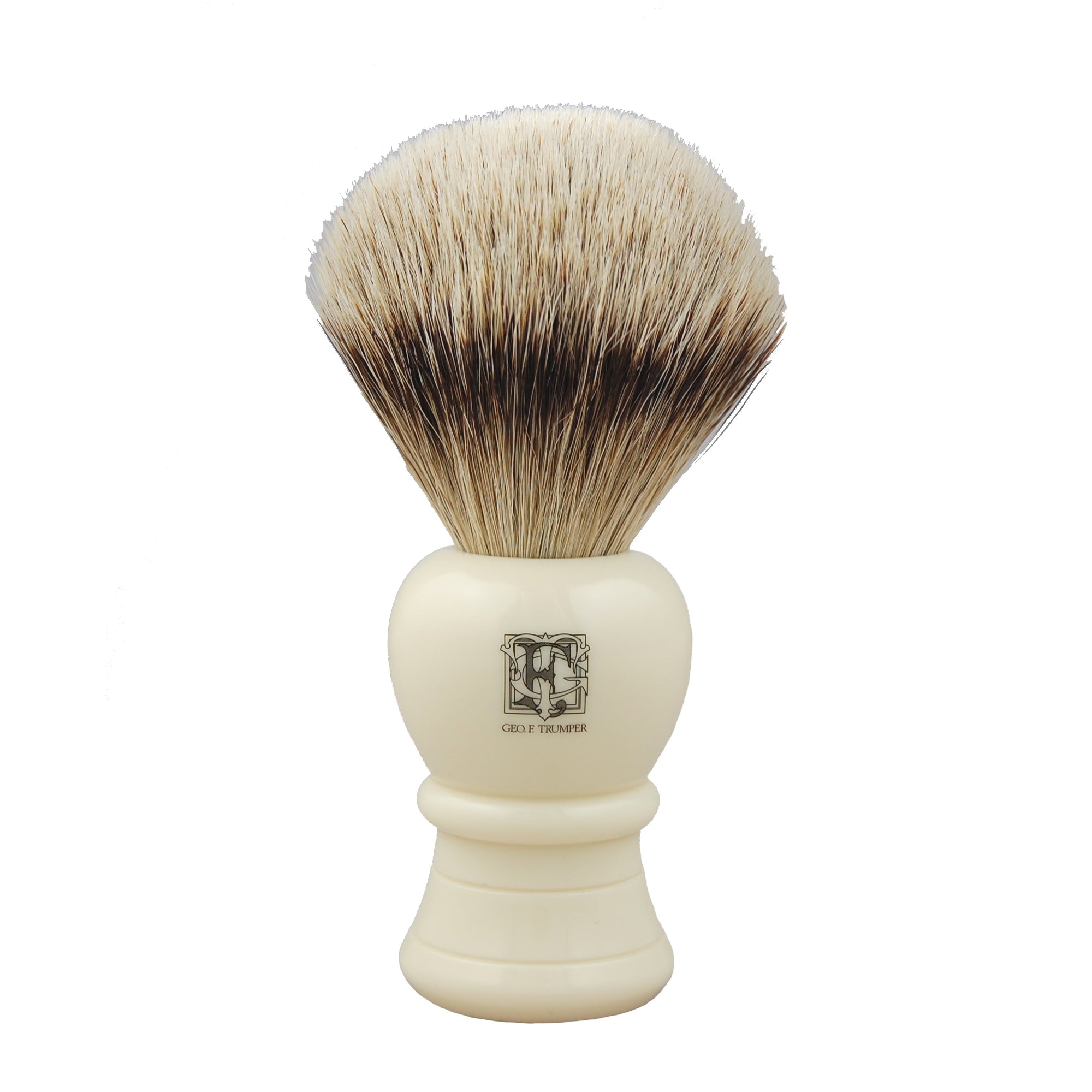 The Geo. F. Trumper Shaving Brush features densely packed badger hair bristles and an ivory-colored handle with a front logo, ideal for wet shaving and creating a rich lather with your favorite cream or soap.