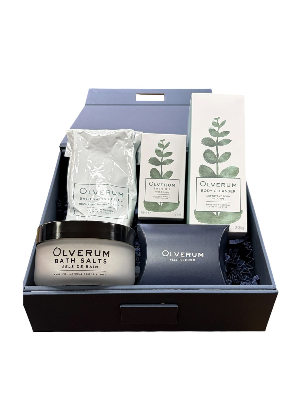 An Olverum Signature Collection gift box containing a jar of bath salts, a bath salts refill pouch, a bottle of bath oil, a bottle of body cleanser, and a small gift box.