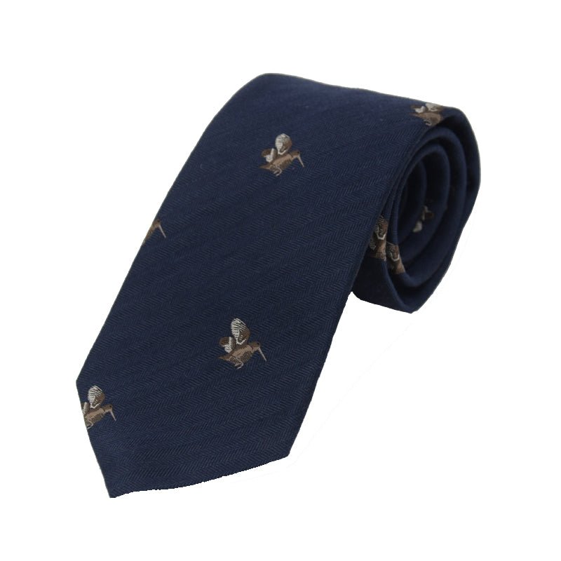 The Woodcock Silk Tie by Campbells of Beauly features a navy silk fabric with a subtle herringbone pattern and a repeating countryside woodcock motif, neatly rolled at one end.