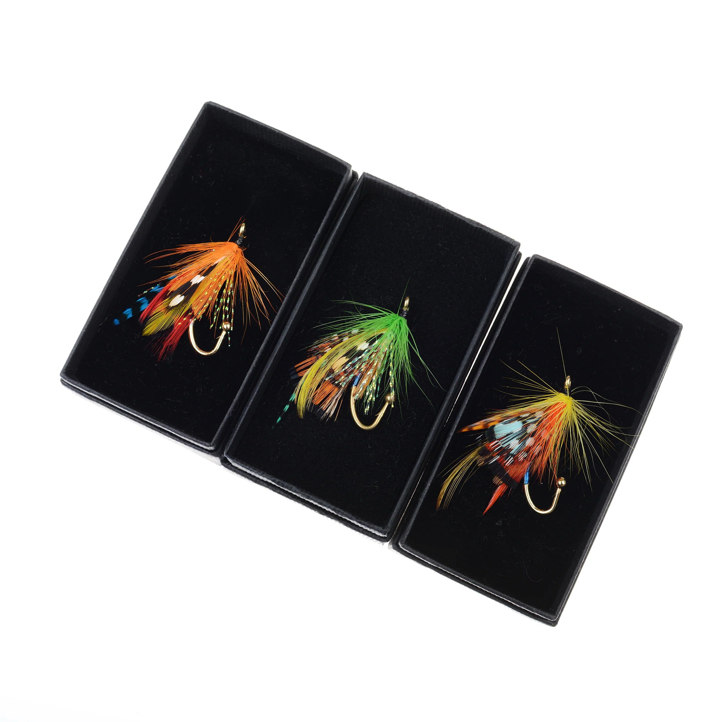 Three Campbell's of Beauly Fly Fishing Brooches, each featuring vibrant feathers and gold hooks, are displayed in black boxes on a white background—unique handmade accessories full of country character.