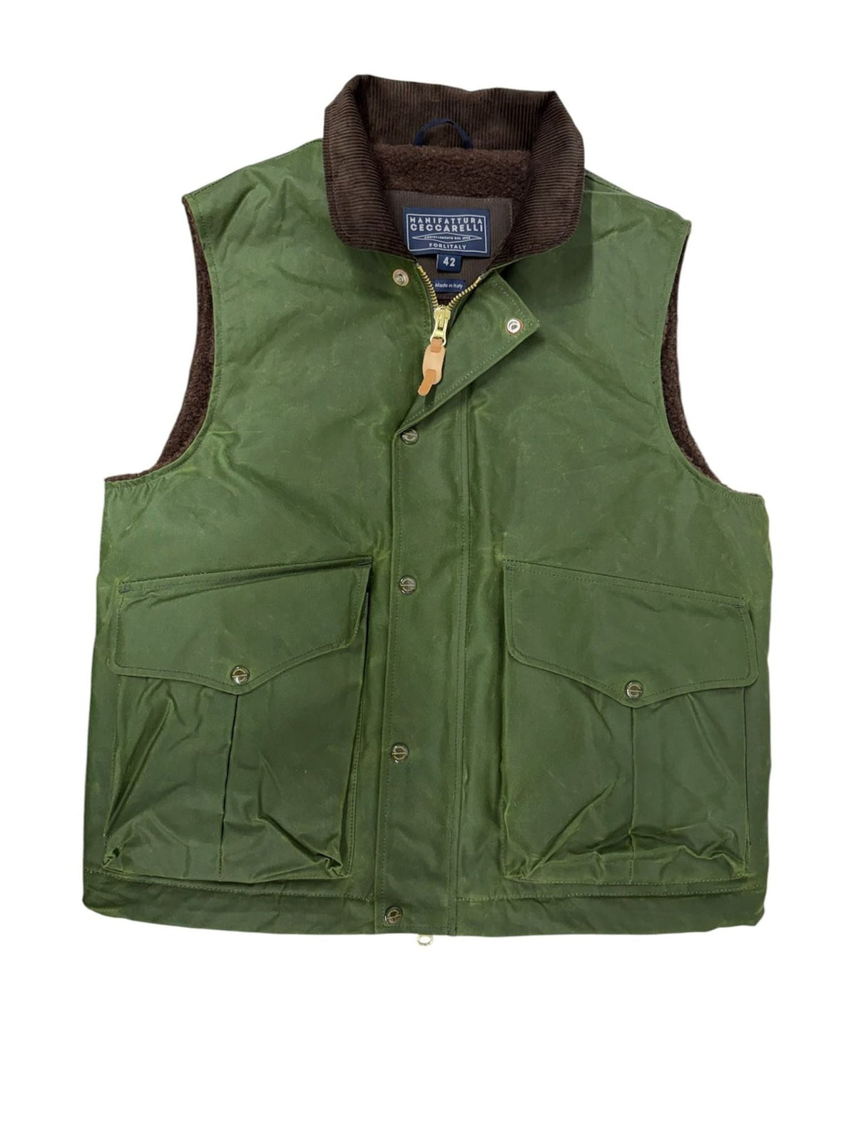 The Campbell’s of Beauly Wax Nehru Gilet in olive features a brown corduroy collar, zip and snap front closure, and two front flap pockets. Expertly crafted in Italy, this waxed cotton vest offers timeless country style and rugged durability.