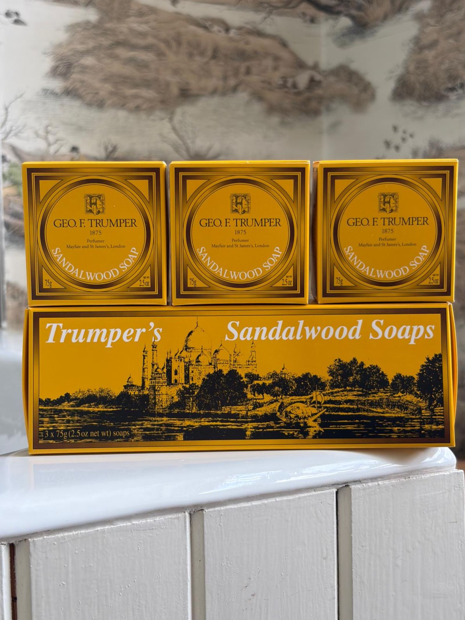Geo. F. Trumper Sandalwood Hand Soaps, Set of 3, are displayed on a coordinating tray—each features classic packaging, making this set an elegant addition to any guest bathroom.