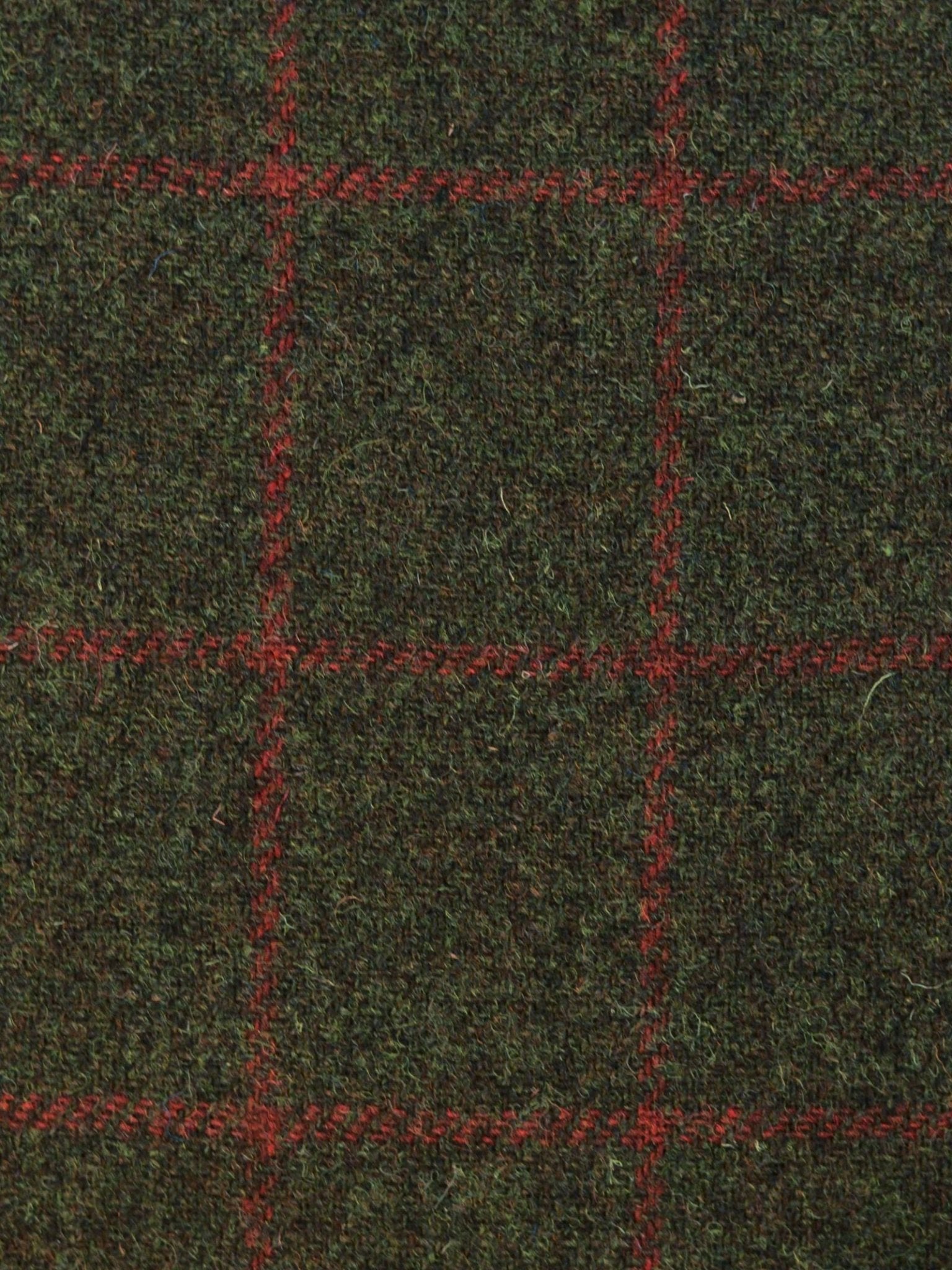 Close-up of Harris Tweed 93907 by Campbell's of Beauly: dark green featherweight tweed with a textured surface and red windowpane plaid, highlighting Scottish weaving heritage.