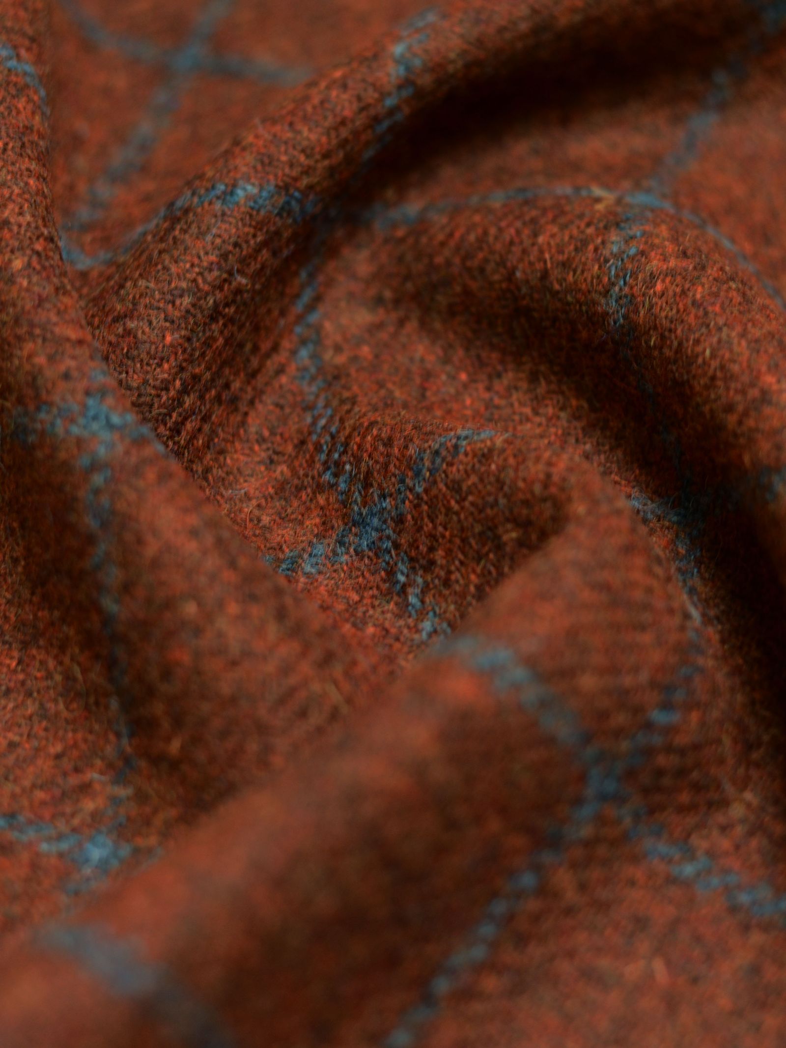 Close-up of Harris Tweed 93903 by Campbell's of Beauly, a brown featherweight tweed with soft texture, blue plaid pattern, and gentle folds—reflecting classic Scottish tailoring.