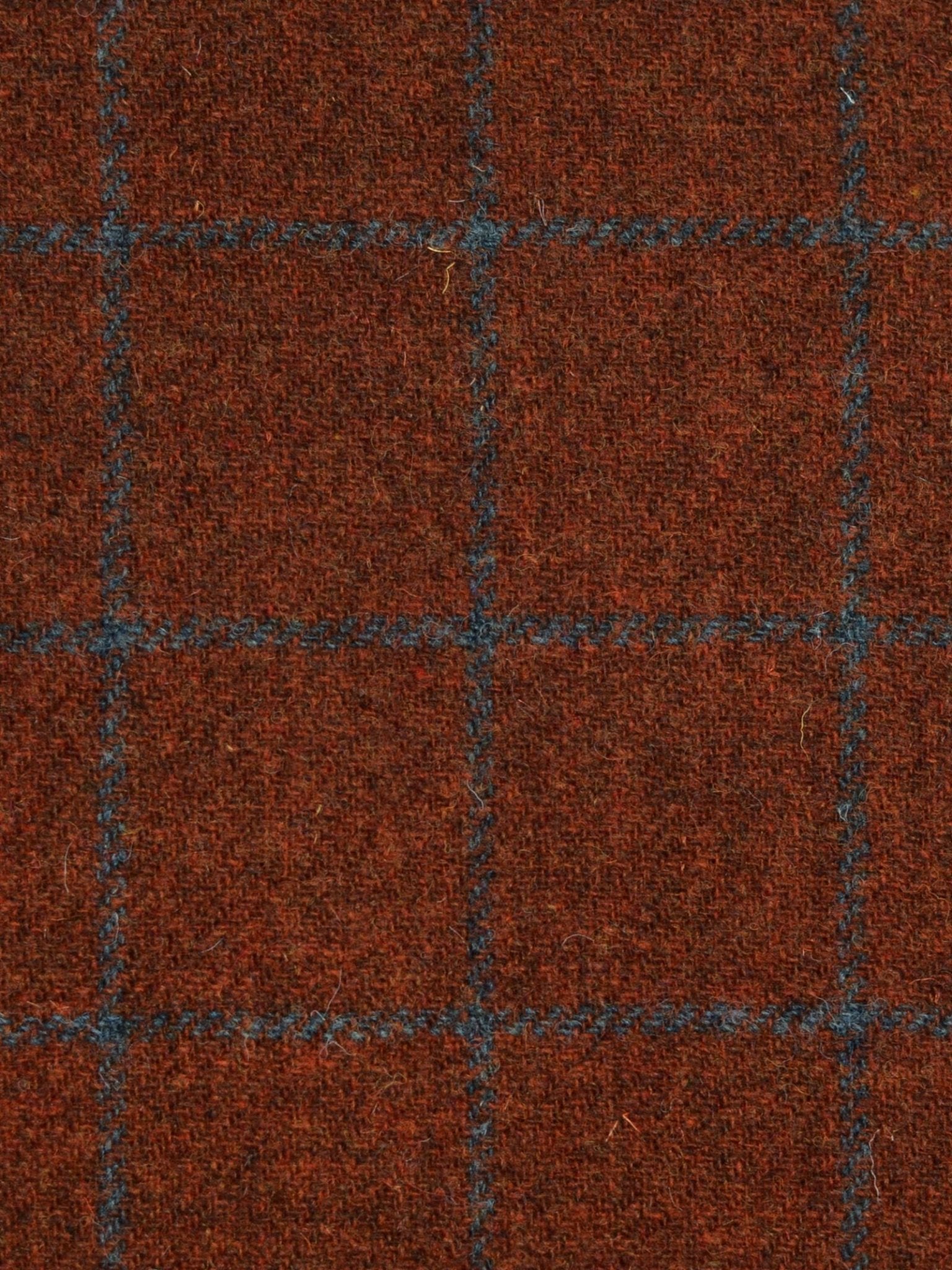 A close-up of Campbell's of Beauly Harris Tweed 93903, showcasing its textured brown fabric with a blue grid pattern, epitomizing classic Scottish tailoring.