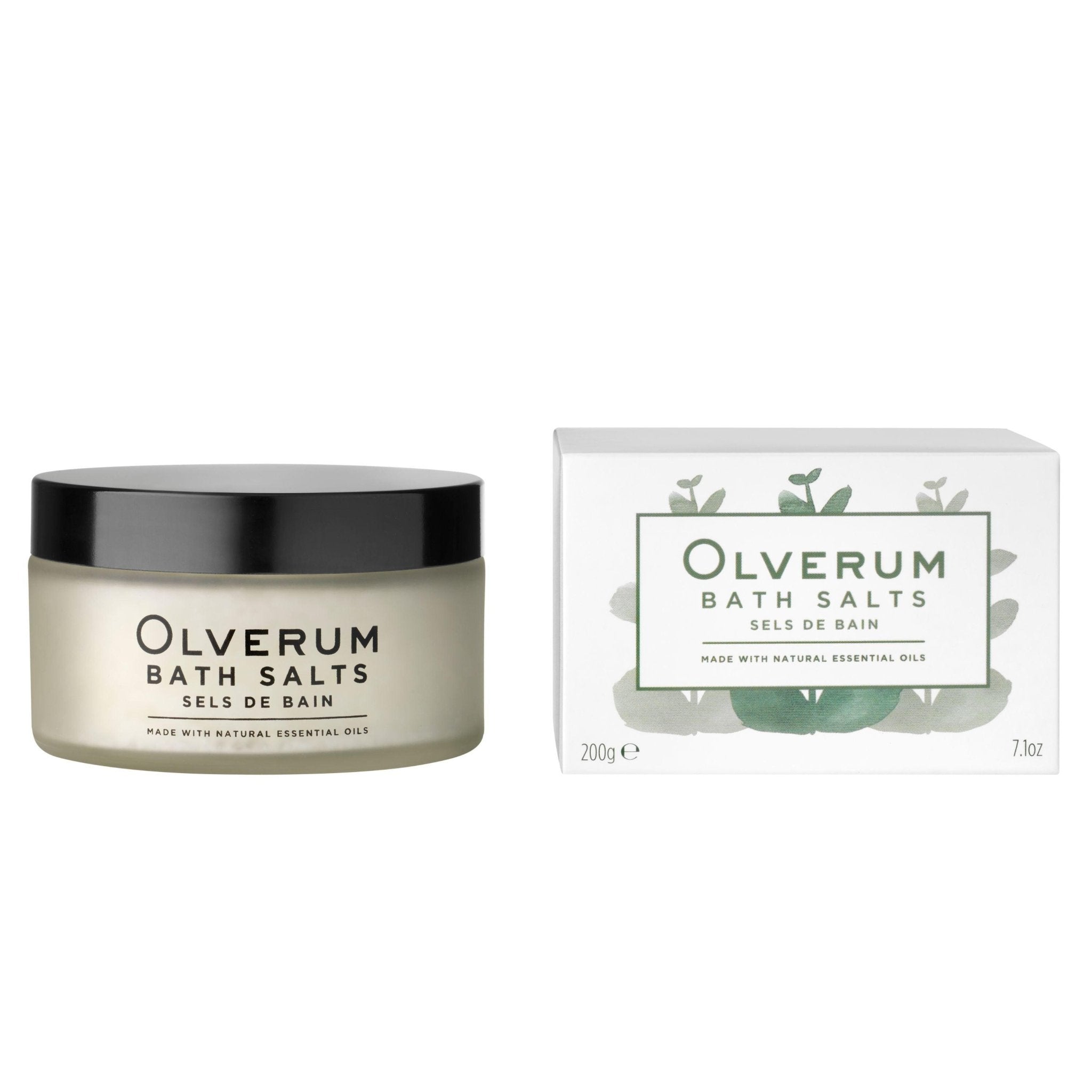 A frosted jar with black lid and an illustrated white box of OLVERUM Bath Salts, labeled in English and French, offer a luxurious mineral soak with essential oils and Dead Sea salt.