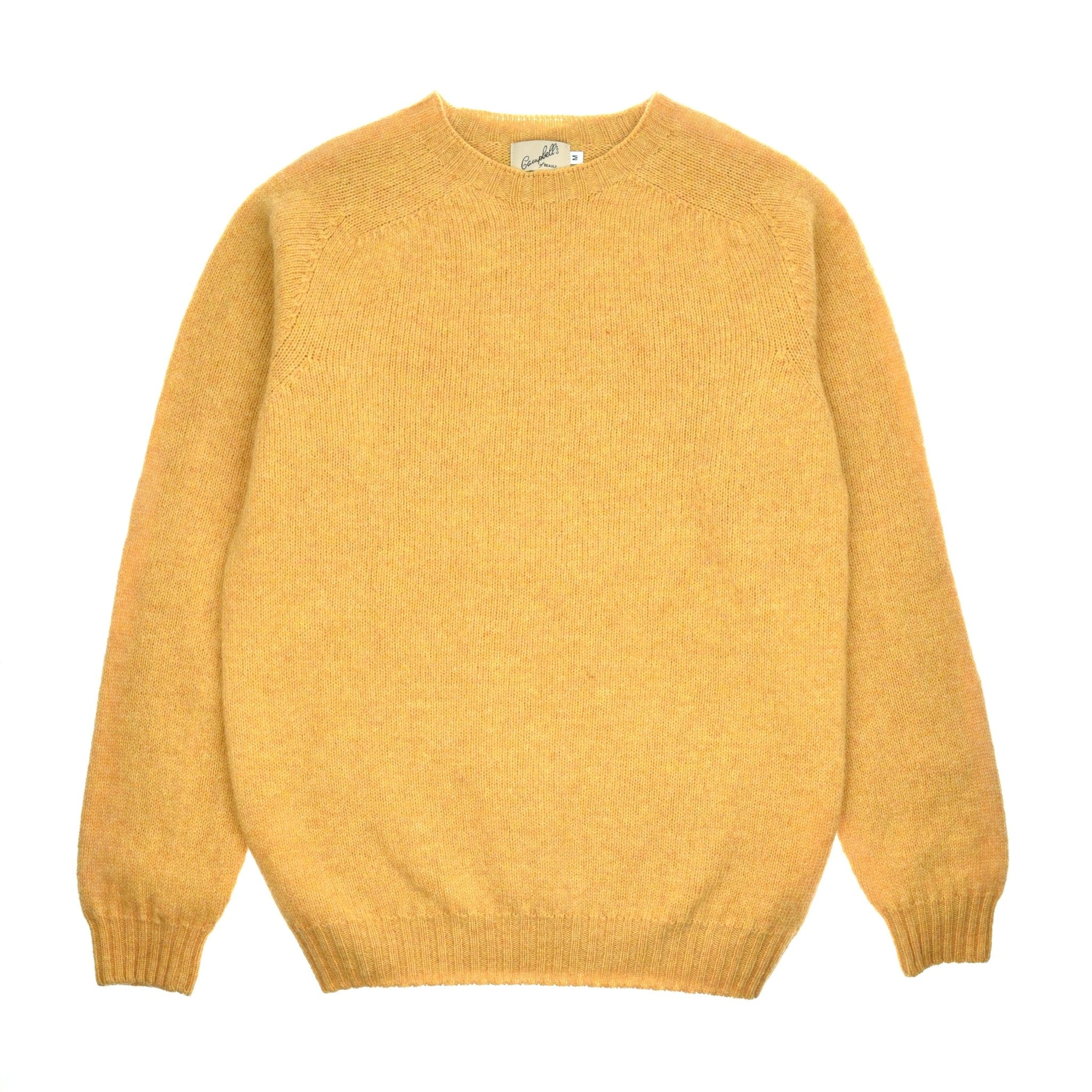 Campbell's of Beauly Shetland Jumper in honey, crafted from Shetland wool with raglan sleeves and ribbed cuffs, hem, and collar. Finished with a small branded label at the back neck. Shown flat on a white background.
