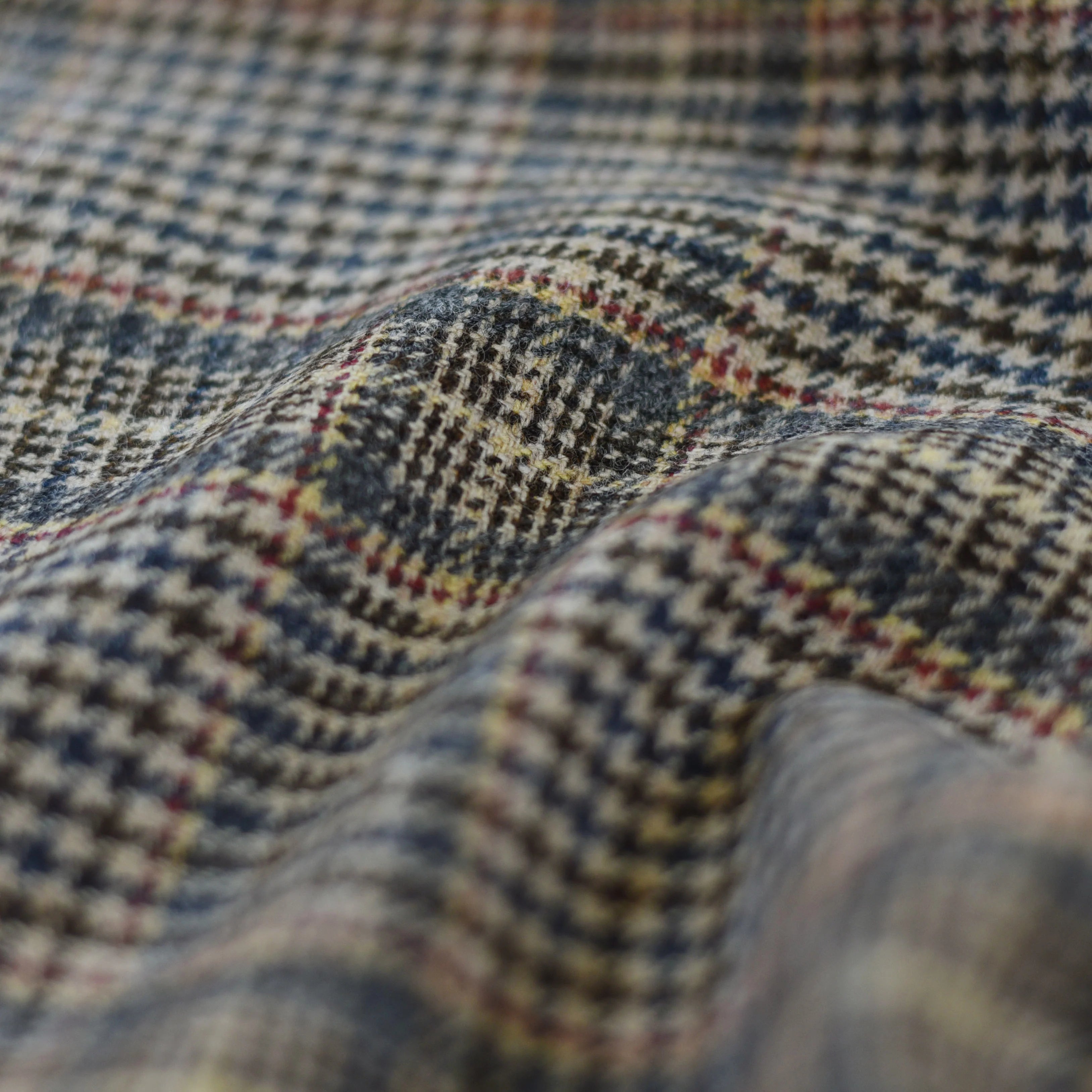 Close-up of House Tweed 77615 by Campbell's of Beauly—a lightweight plaid tweed in blue, yellow, and brown tones, showing soft folds and detailed weave. Expertly woven in England for a classic touch.