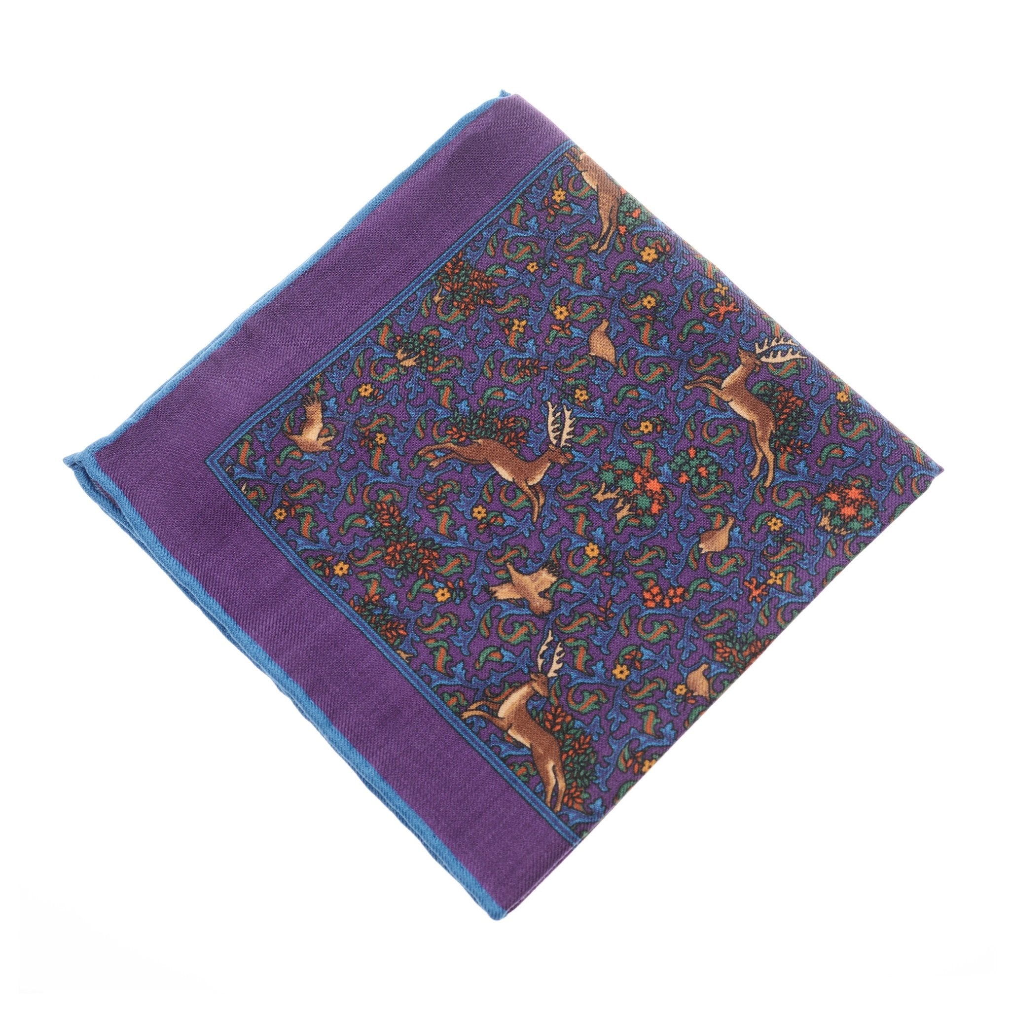 The Campbells of Beauly Wool Hank is a timeless purple pocket square featuring hand-rolled edges and an intricate deer and floral design on a blue background.
