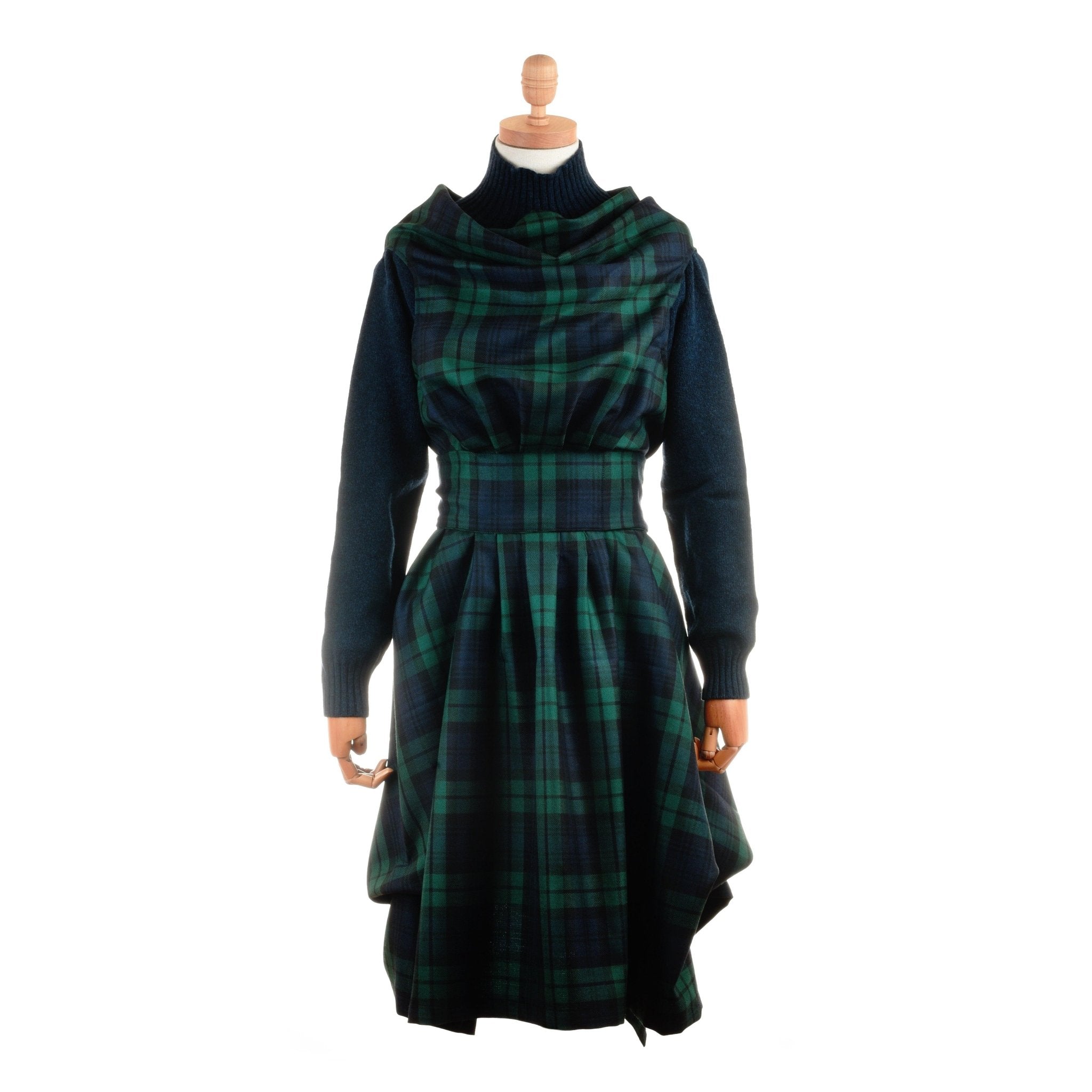 A mannequin displays a green and navy blue Reversible Wool Wrap Dress by Campbell's of Beauly, featuring long sleeves, a fitted waist, and an asymmetrical skirt, set against a white background.
