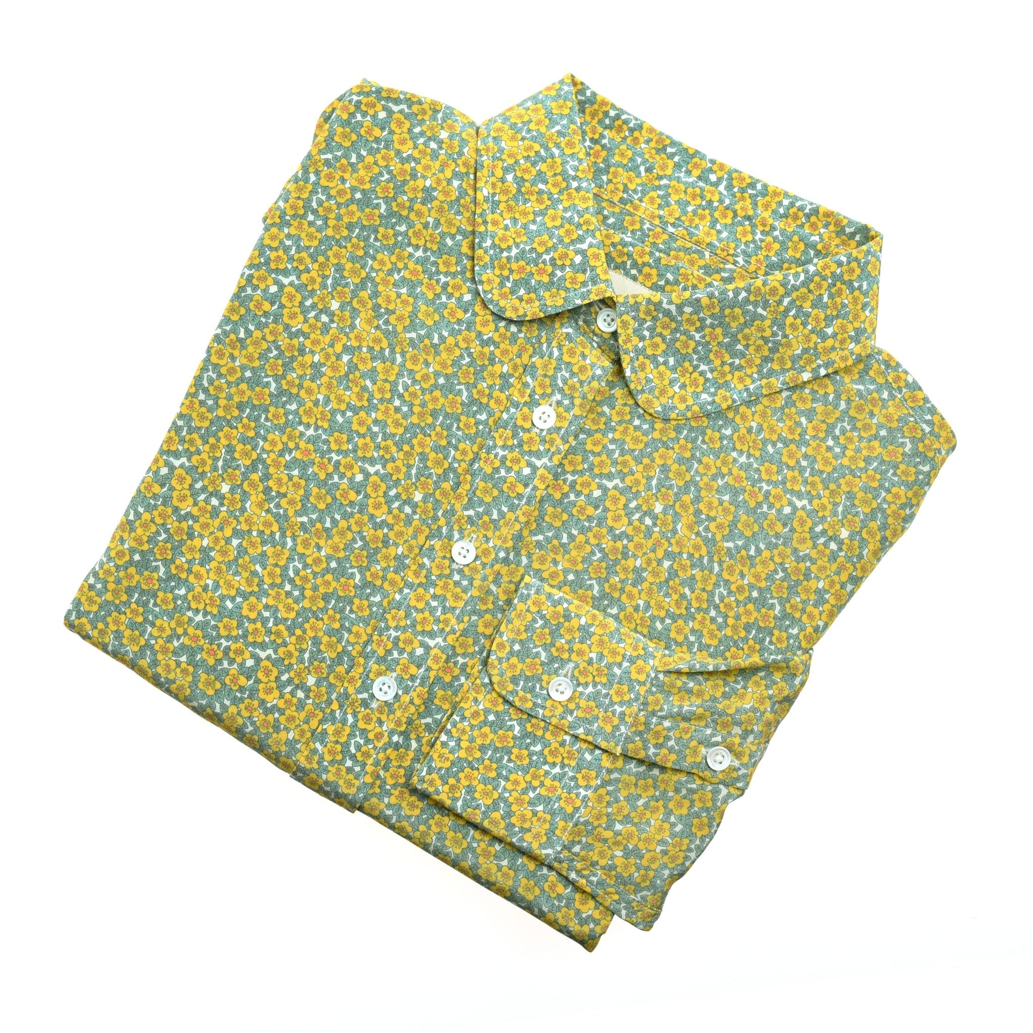 The Auld Stock Liberty Print Silk Shirt by Campbell's of Beauly, featuring yellow and blue small florals on light green silk, is neatly folded and displayed on a white surface.