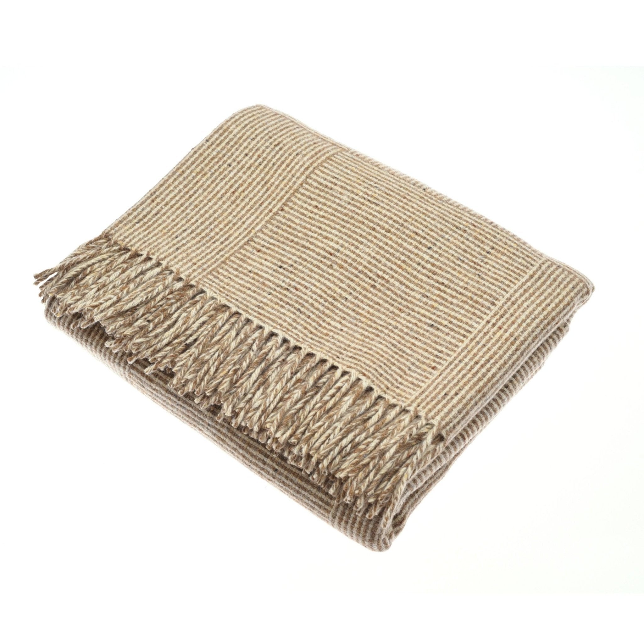 The Cabrich Lambswool Throw by Campbell's of Beauly, a beige Irish-woven blanket with thin stripes and fringed edges, made from Donegal wool, is displayed against a white background.