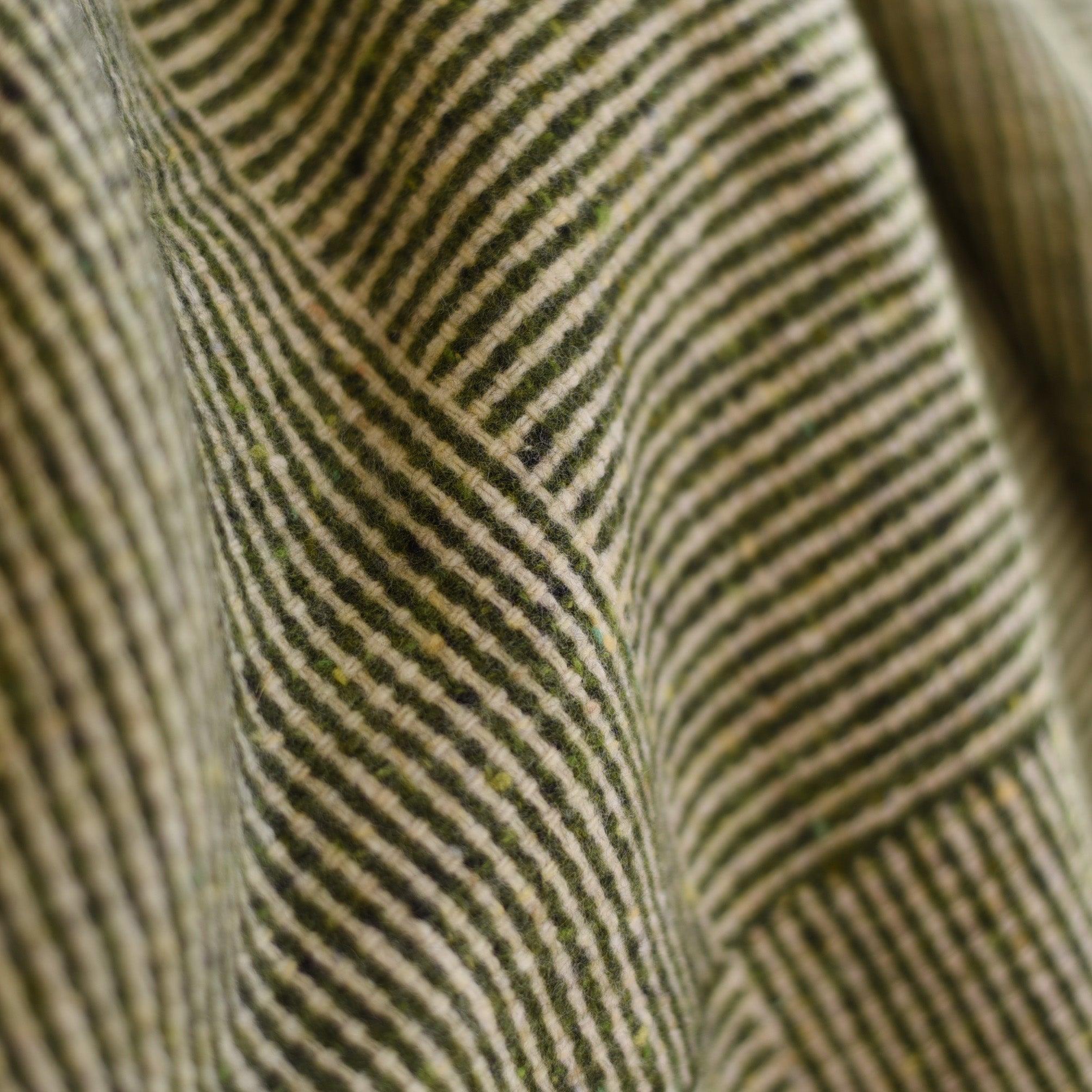 Close-up of the Campbells of Beauly Cabrich Lambswool Throw, featuring diagonal green and beige stripes that highlight its basket weave pattern, texture, and soft folds.