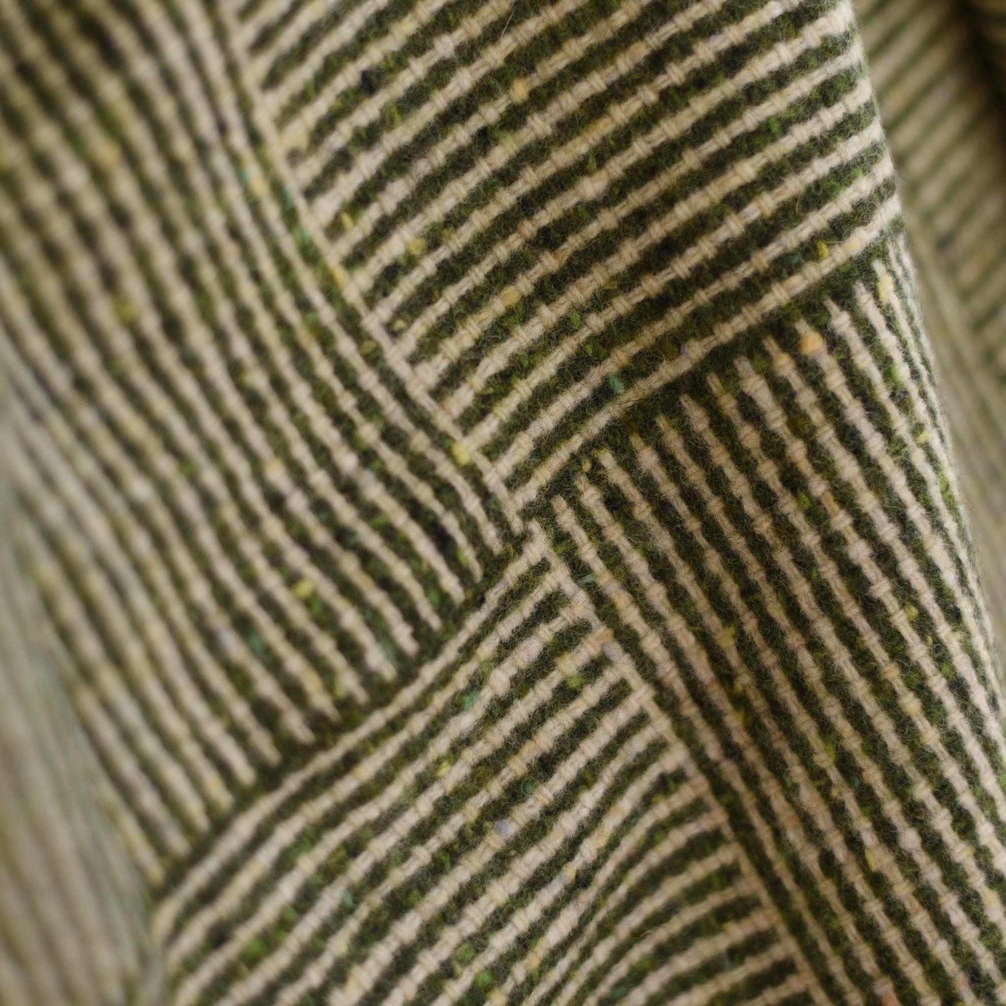 Close-up of the Cabrich Lambswool Throw by Campbells of Beauly, featuring Donegal wool with a basket weave pattern of diagonal and horizontal green and cream stripes, highlighting its rich texture and overlapping design.