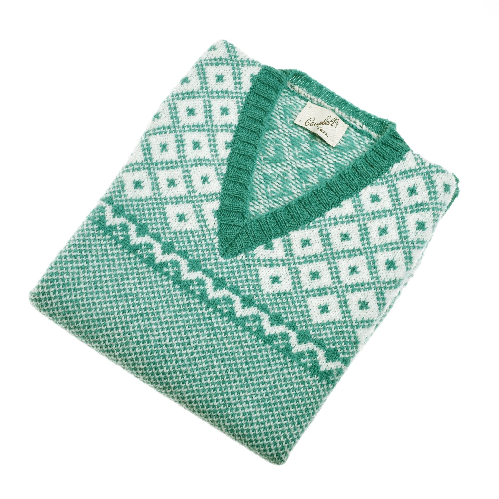 The Campbell's of Beauly Auld Stock Nordic V Tank, a folded green and white Shetland wool sweater with a diamond pattern and ribbed V-neck, inspired by classic Fair Isle design, is displayed on a white background.