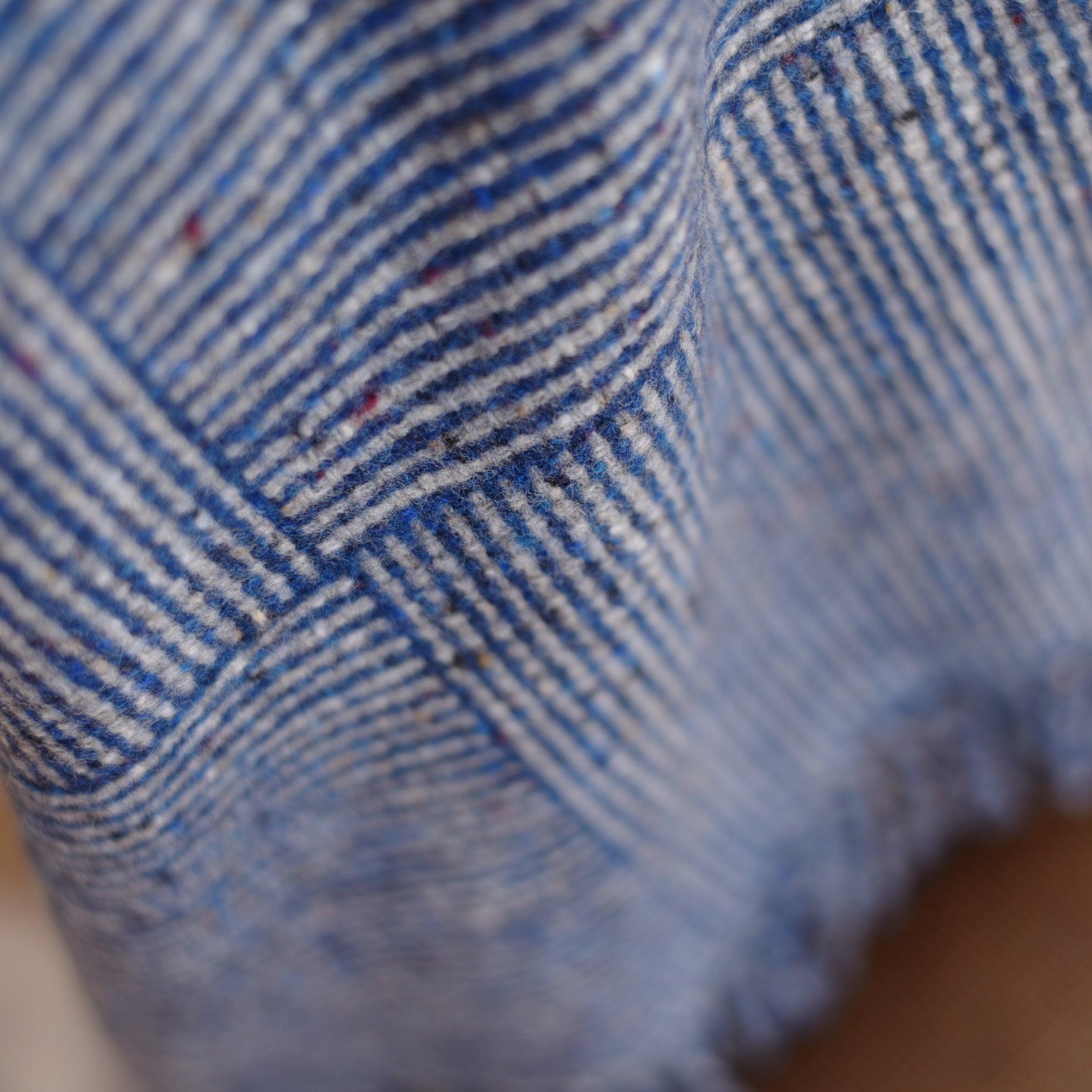 A close-up of the Cabrich Lambswool Throw by Campbells of Beauly shows its blue and white plaid basket weave pattern, textured woven surface, and soft, cozy look—echoing the warmth of a classic lambswool blanket.
