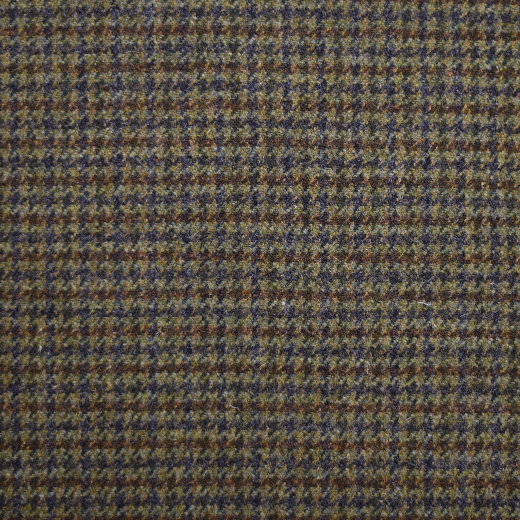 A close-up of House Tweed 84927 by Campbell's of Beauly, featuring brown, green, and gray field tweed with a textured small-scale houndstooth pattern that highlights classic Scottish craftsmanship.