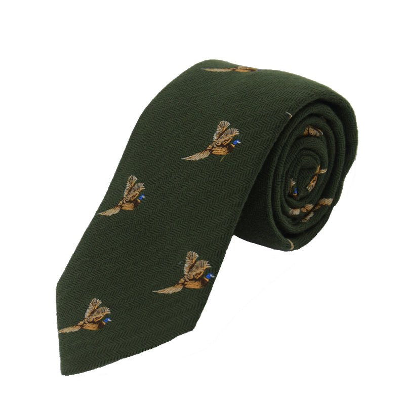 The Campbells of Beauly Pheasant In Flight Silk Tie is a green silk necktie featuring a repeating pheasant-in-flight motif, with each bird holding a blue flower in its beak.