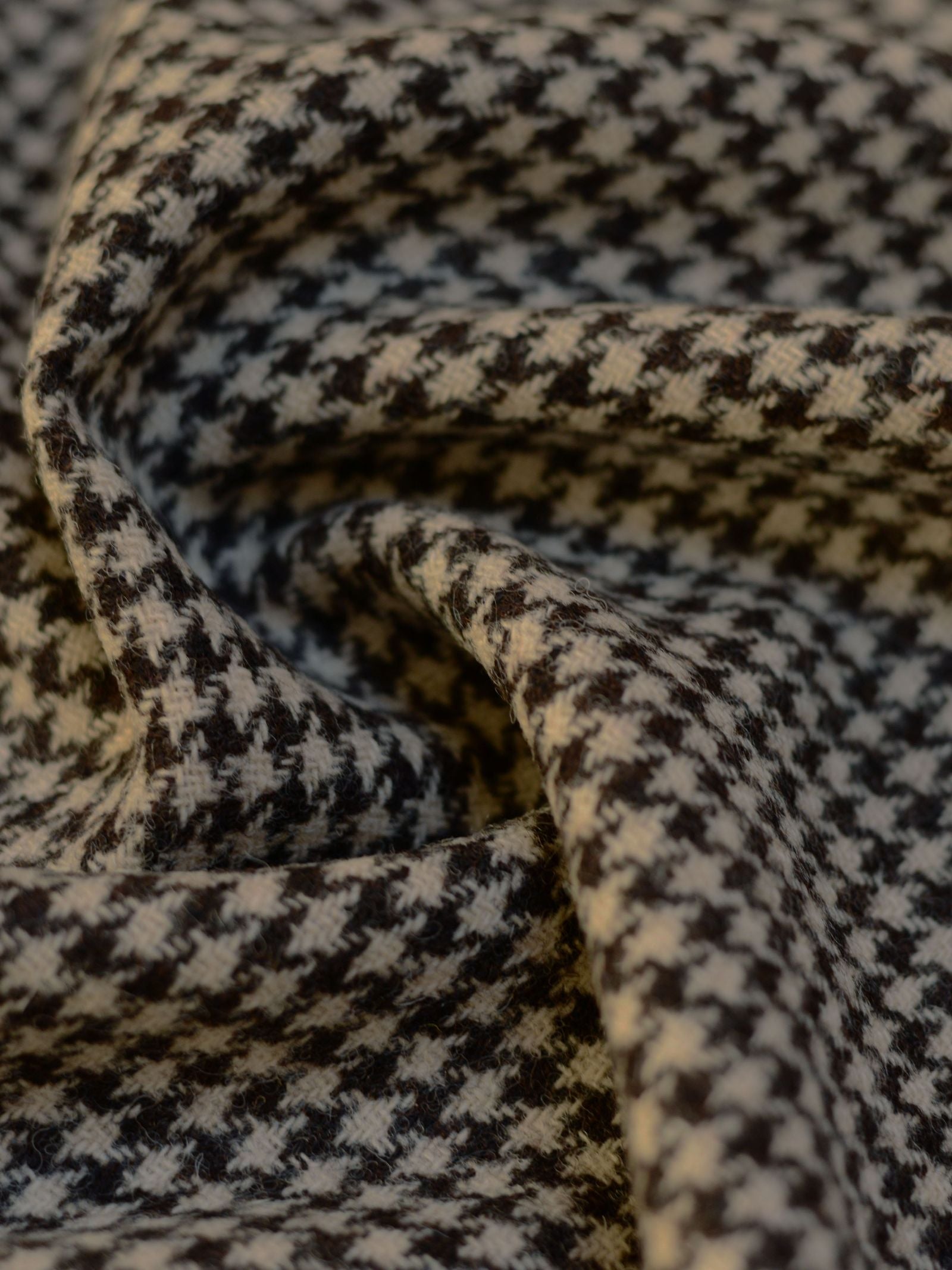 Close-up of the black and white houndstooth fabric, Harris Tweed 93898 by Campbell's of Beauly, gently folded to highlight the woven texture and detail—crafted in the tradition of Scottish weaving.