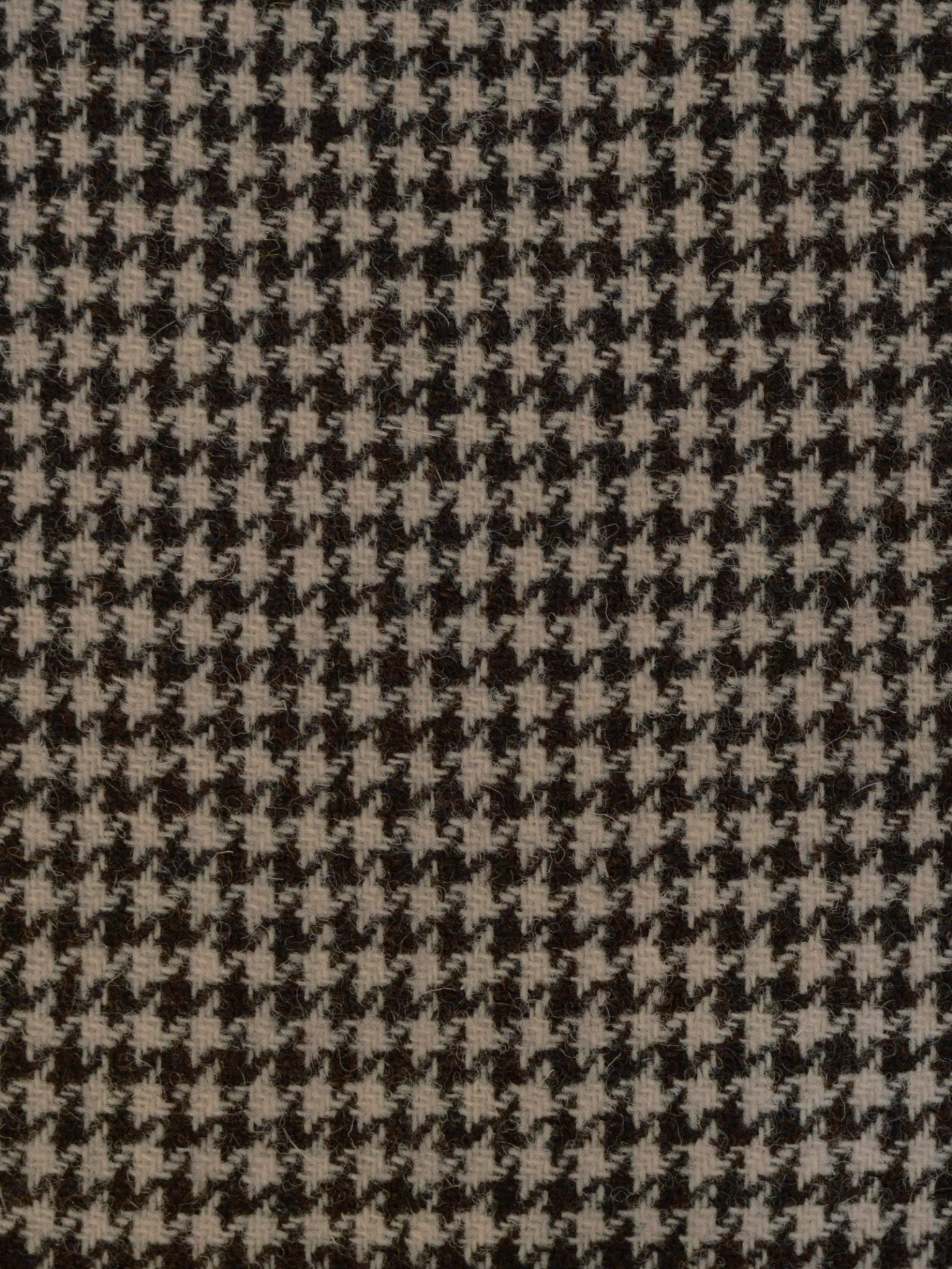Close-up of Harris Tweed 93898 by Campbell's of Beauly, showcasing a black and white houndstooth pattern with distinctive jagged shapes inspired by traditional Scottish weaving.
