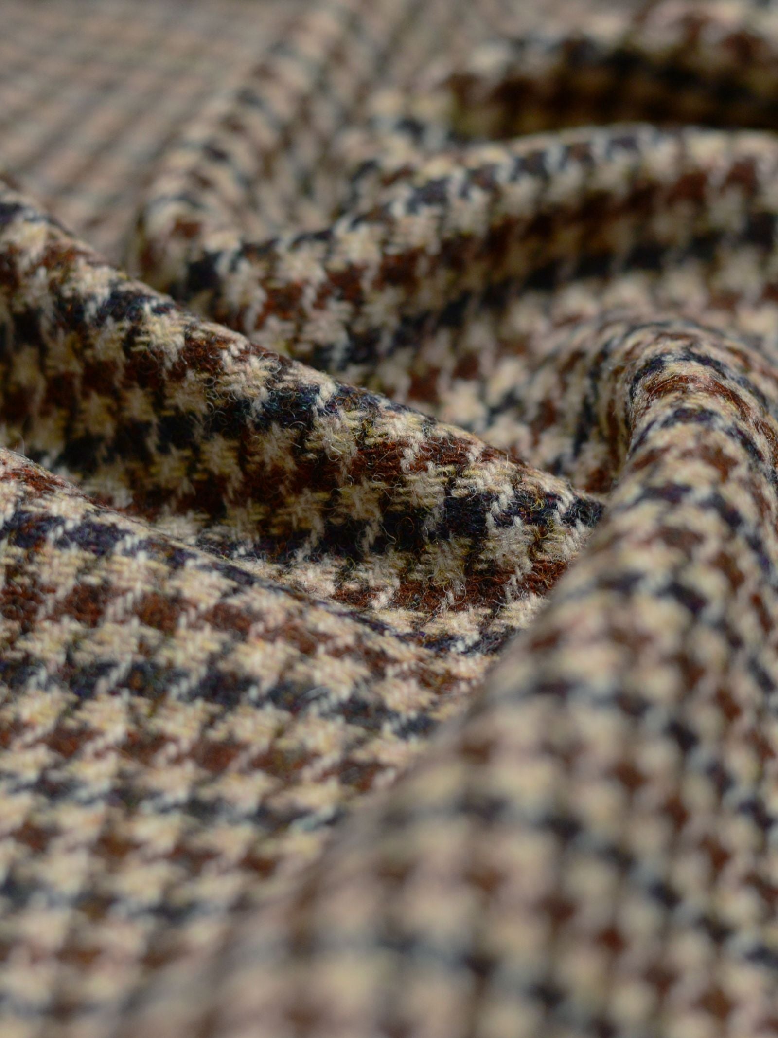 Close-up of Harris Tweed 93896 by Campbell's of Beauly, highlighting the textured wool fabric in a brown, beige, and black houndstooth pattern inspired by classic Scottish weaving.