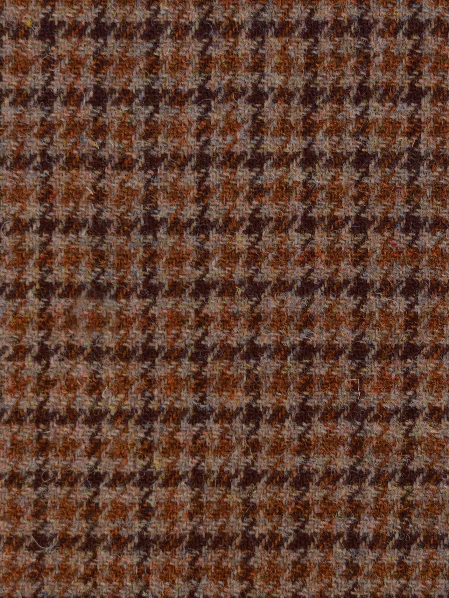 Close-up of Harris Tweed 93910 by Campbell's of Beauly, featuring a brown, orange, and beige houndstooth pattern with a classic checkered design and visible textured wool fibers.