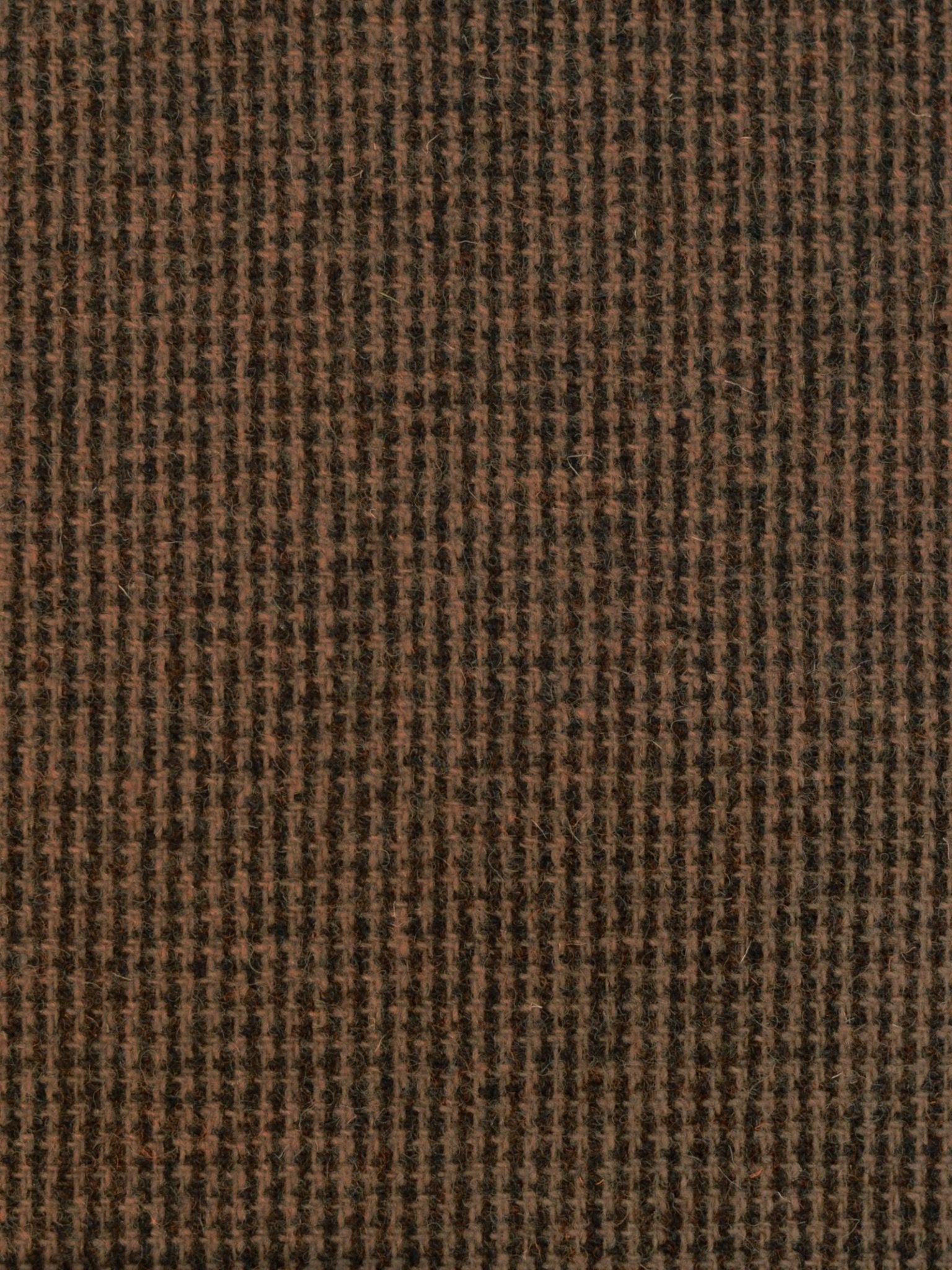 Close-up of Campbell's of Beauly Harris Tweed 93905: a brown and black houndstooth fabric featuring a textured, woven finish. The classic geometric pattern highlights traditional Scottish craftsmanship in a timeless checkered style.