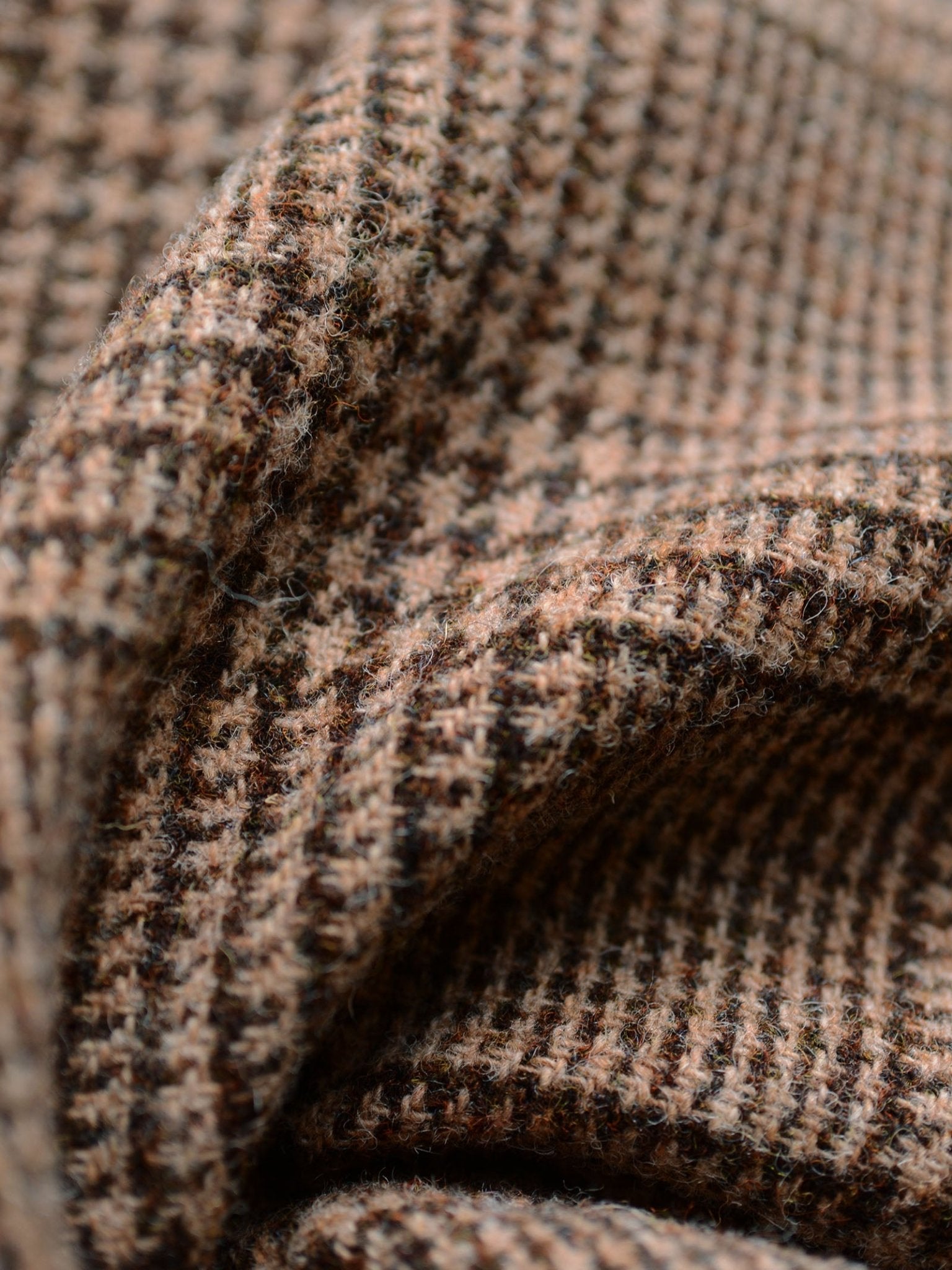 Close-up of Campbell's of Beauly Harris Tweed 79336, highlighting the brown and beige houndstooth pattern, textured weave, and soft folds of this classic fabric.