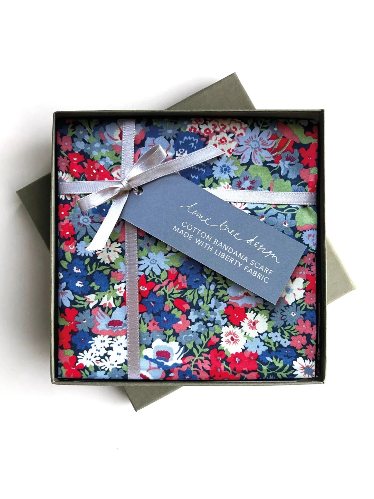 A floral cotton Square Headscarf by Campbell's of Beauly in red, blue, and white, neatly gift-boxed with a silver ribbon and a blue tag reading "Campbell's of Beauly Square Headscarf Made with Liberty Fabric.