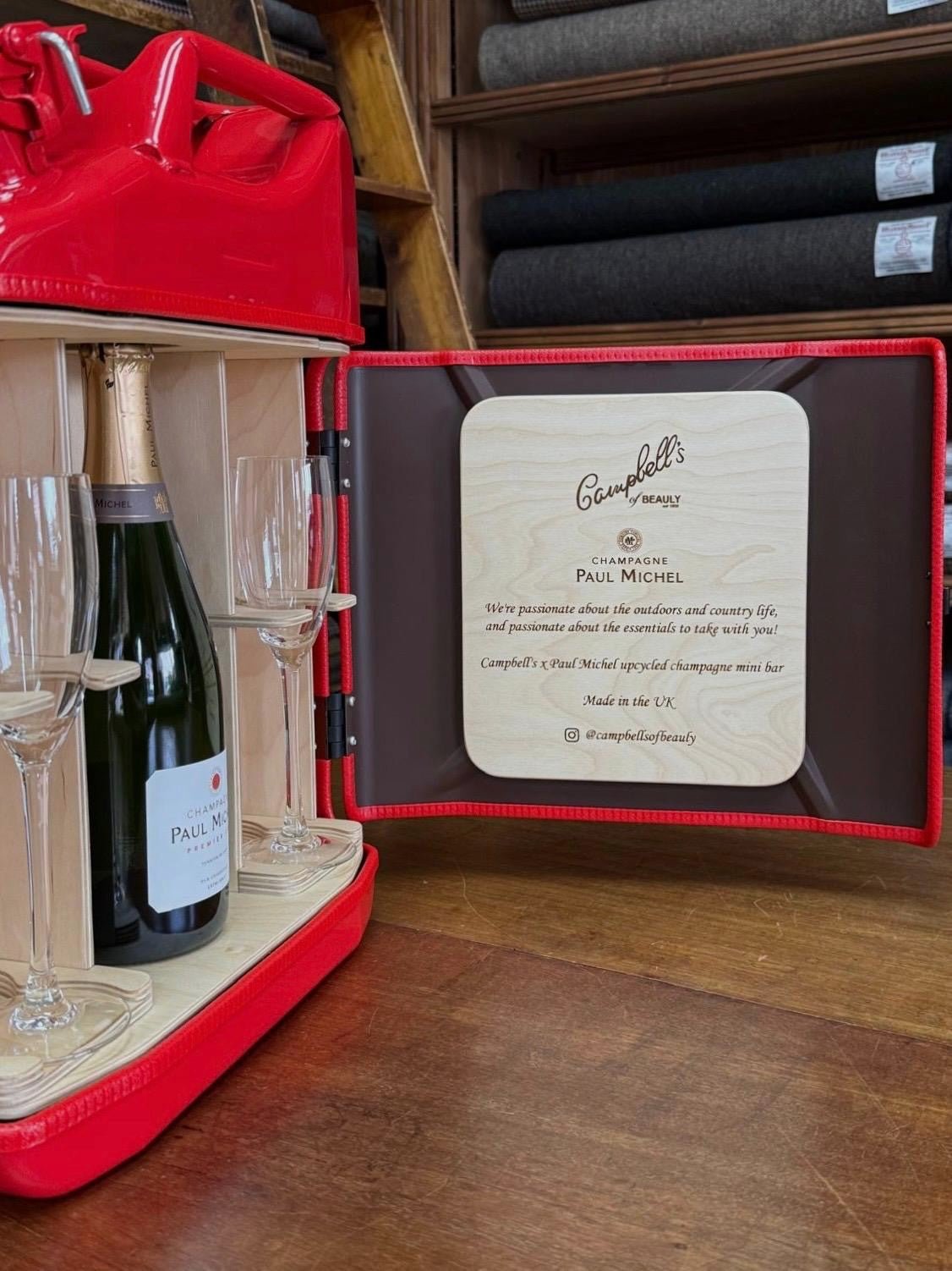 The Paul Michel Champagne Upcycled Mini Bar by Campbell's of Beauly opens to reveal Paul Michel champagne, three flutes, and a wooden info plaque about Campbell’s Country champagne—an elegant piece for any wooden floor.