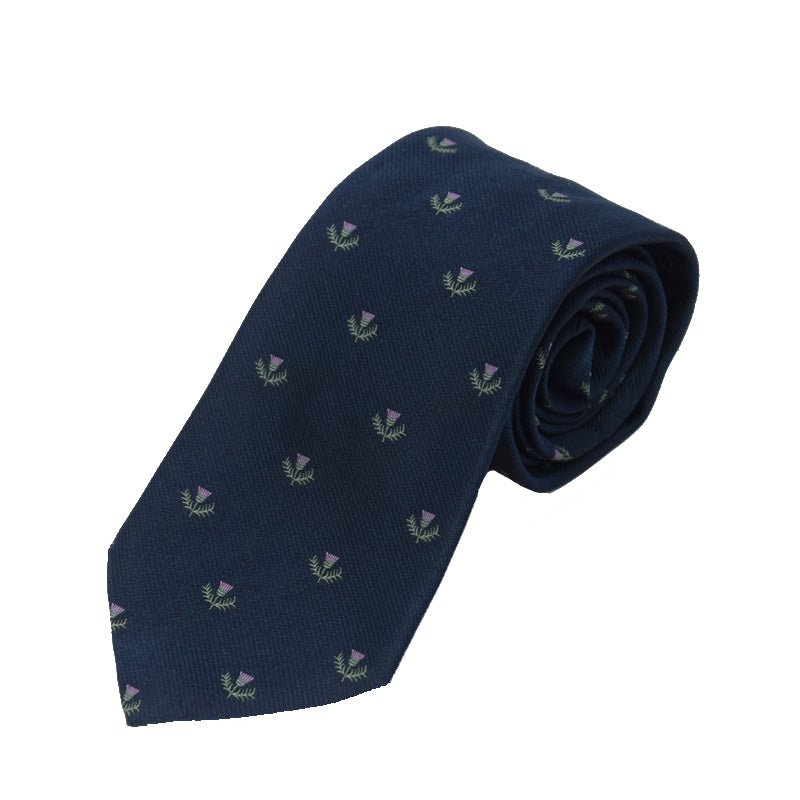 The Campbells of Beauly Thistle Silk Tie features a navy blue base with embroidered purple and green thistles—ideal for formal occasions and celebrating Scottish heritage. Pictured rolled at one end on a white background.