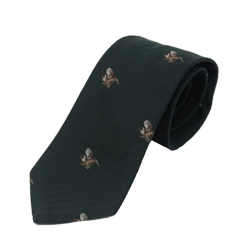 The Woodcock Silk Tie by Campbells of Beauly is a green silk necktie featuring a subtle pattern with playful embroidered brown and white dogs, adding a charming countryside touch to the fine-quality fabric.