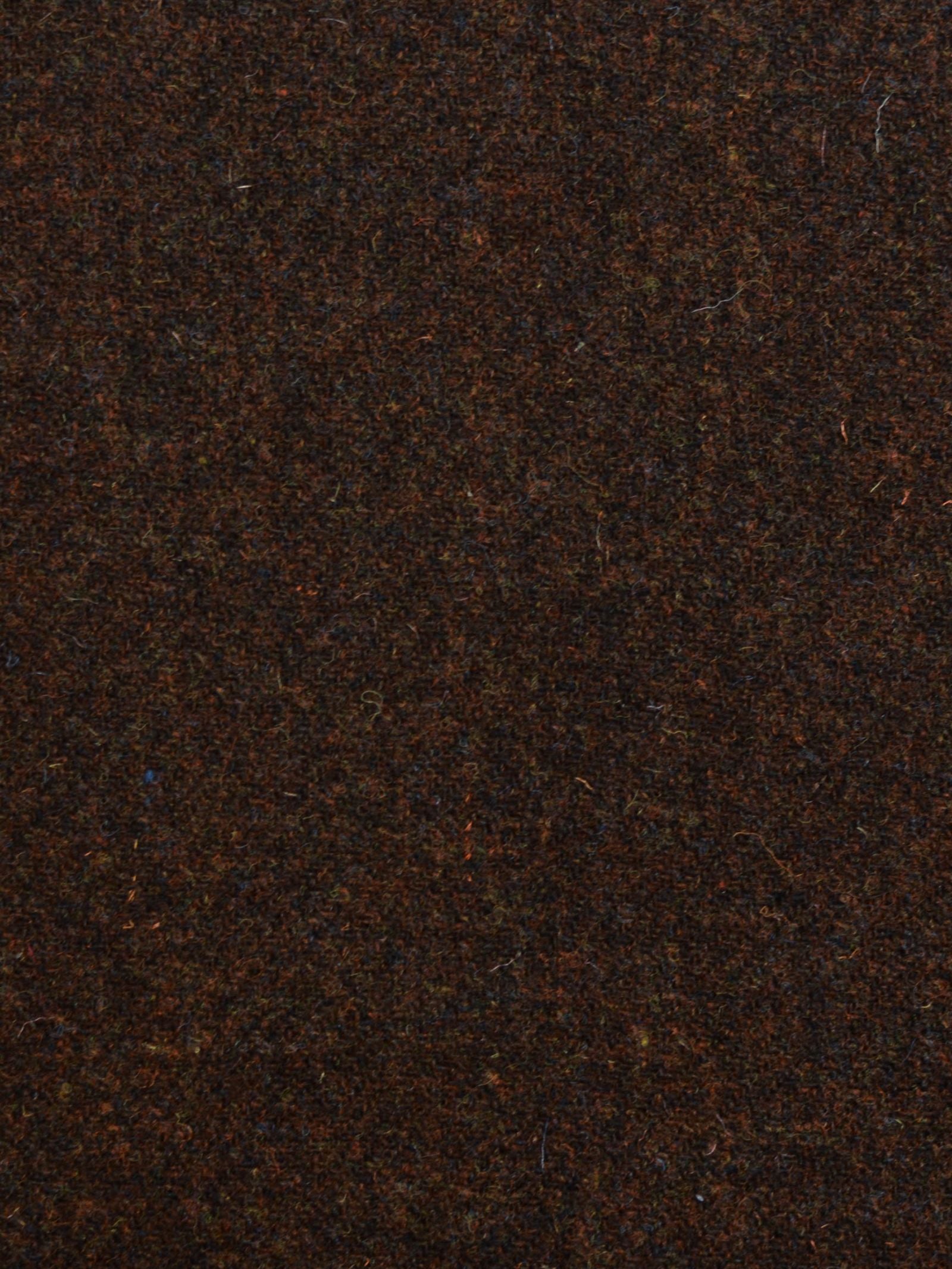 Close-up of Harris Tweed 93893 by Campbell’s of Beauly: a brown fabric with a coarse, textured surface and subtle shade variations, showcasing visible fibers and the iconic Scottish craftsmanship behind this classic material.