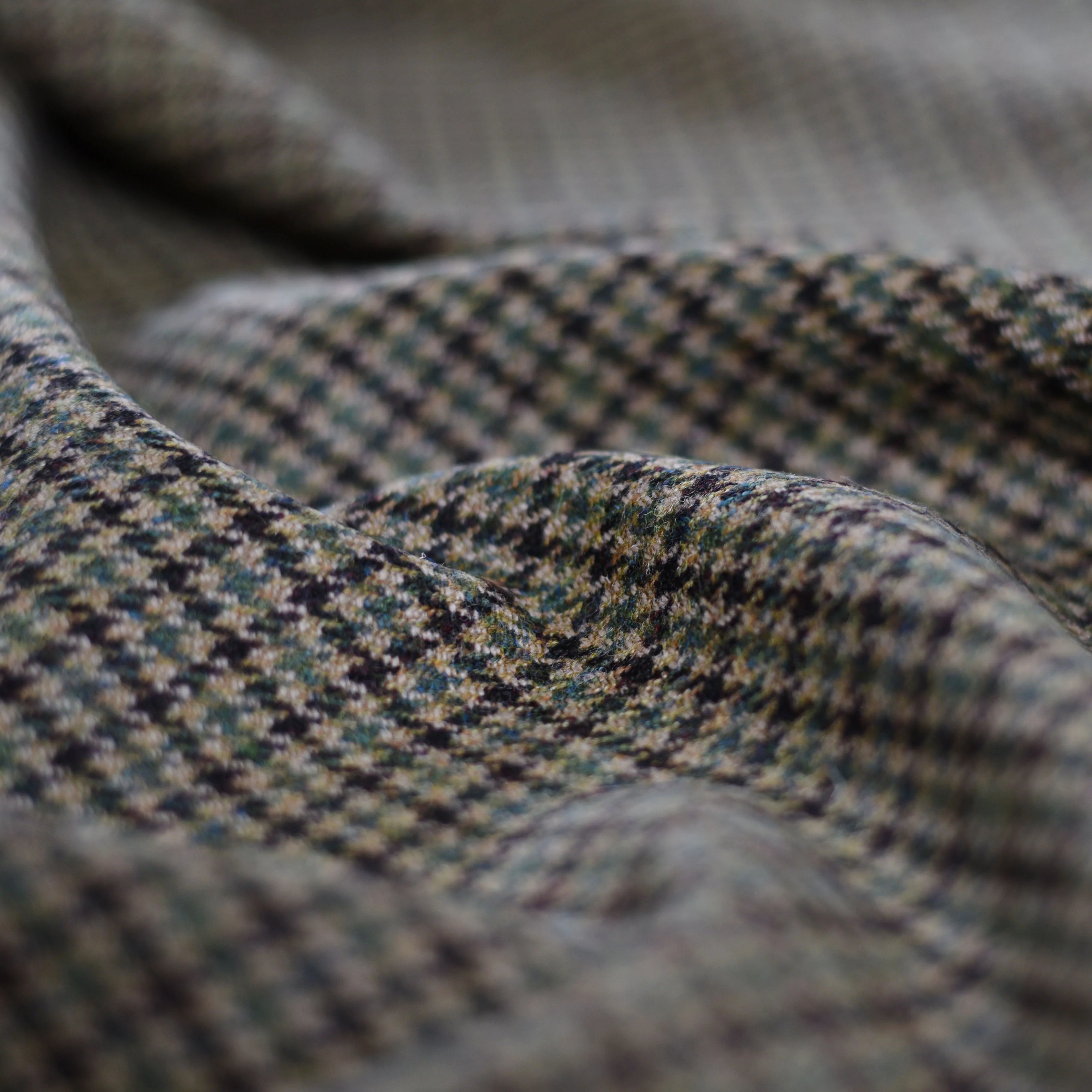 A close-up of House Tweed 75369 by Campbells of Beauly, featuring a small houndstooth pattern in grey, black, and beige with gentle folds—highlighting the quality and heritage of classic Saxony Tweed craftsmanship.