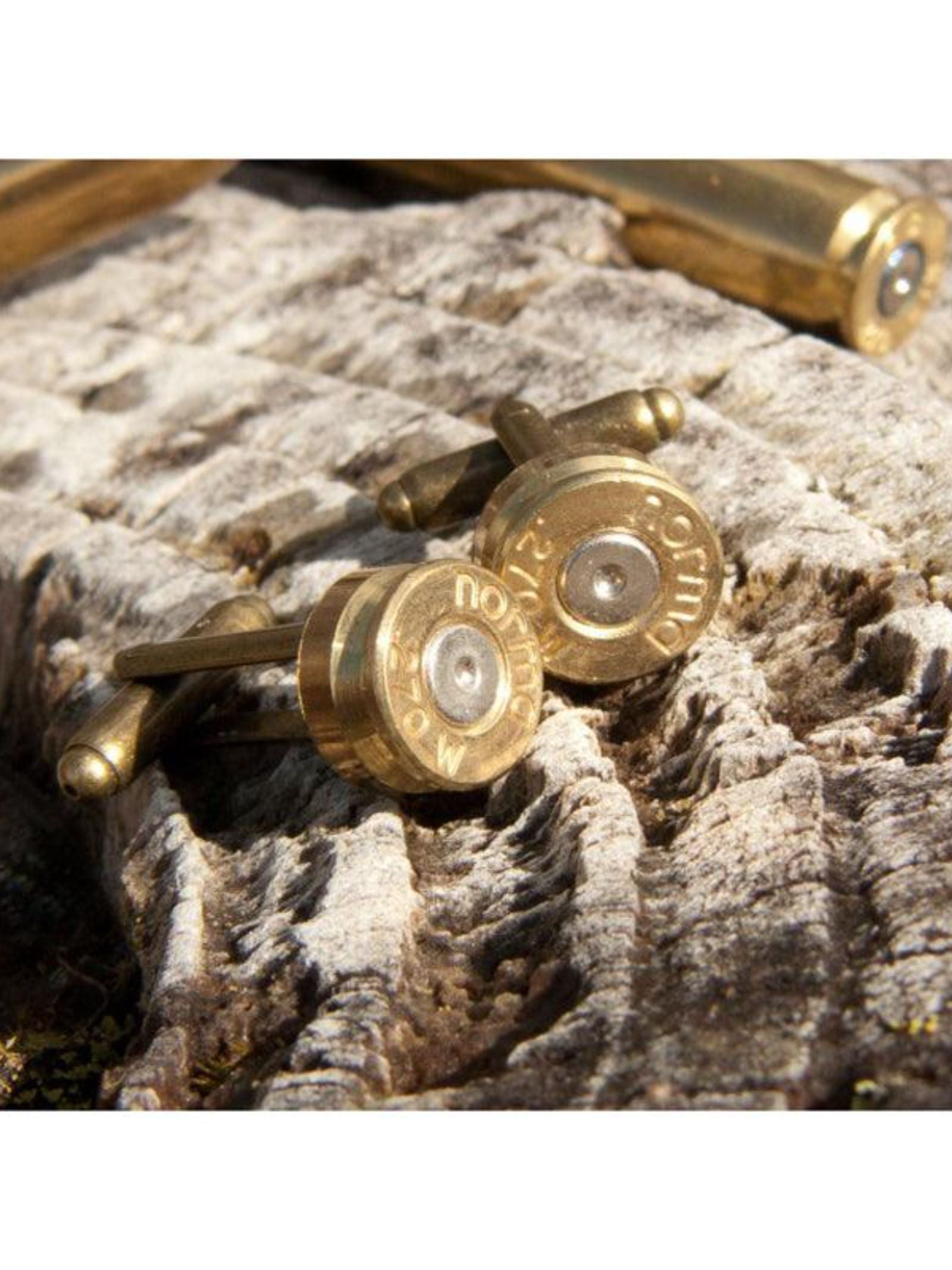 Campbell's of Beauly Bullet Cufflinks, crafted in Scotland from recycled bullets, feature engraved markings and metallic details. Photographed on weathered wood, they make a unique gift for shooting enthusiasts.