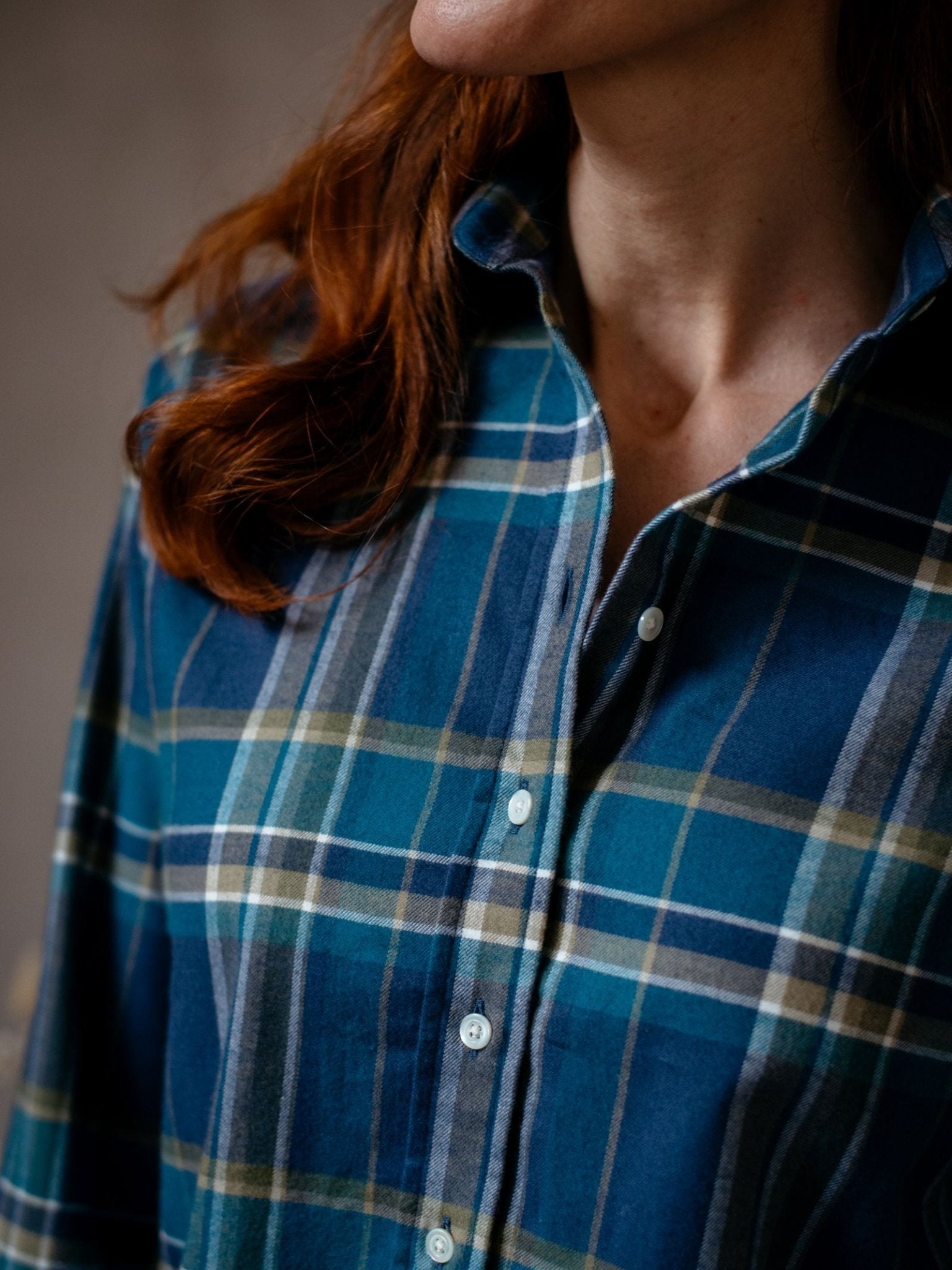 A person with long red hair wears the Campbell's of Beauly Auld Stock Brushed Cotton Shirt in a plaid pattern. The image is cropped to show only part of the face, neck, and upper torso.