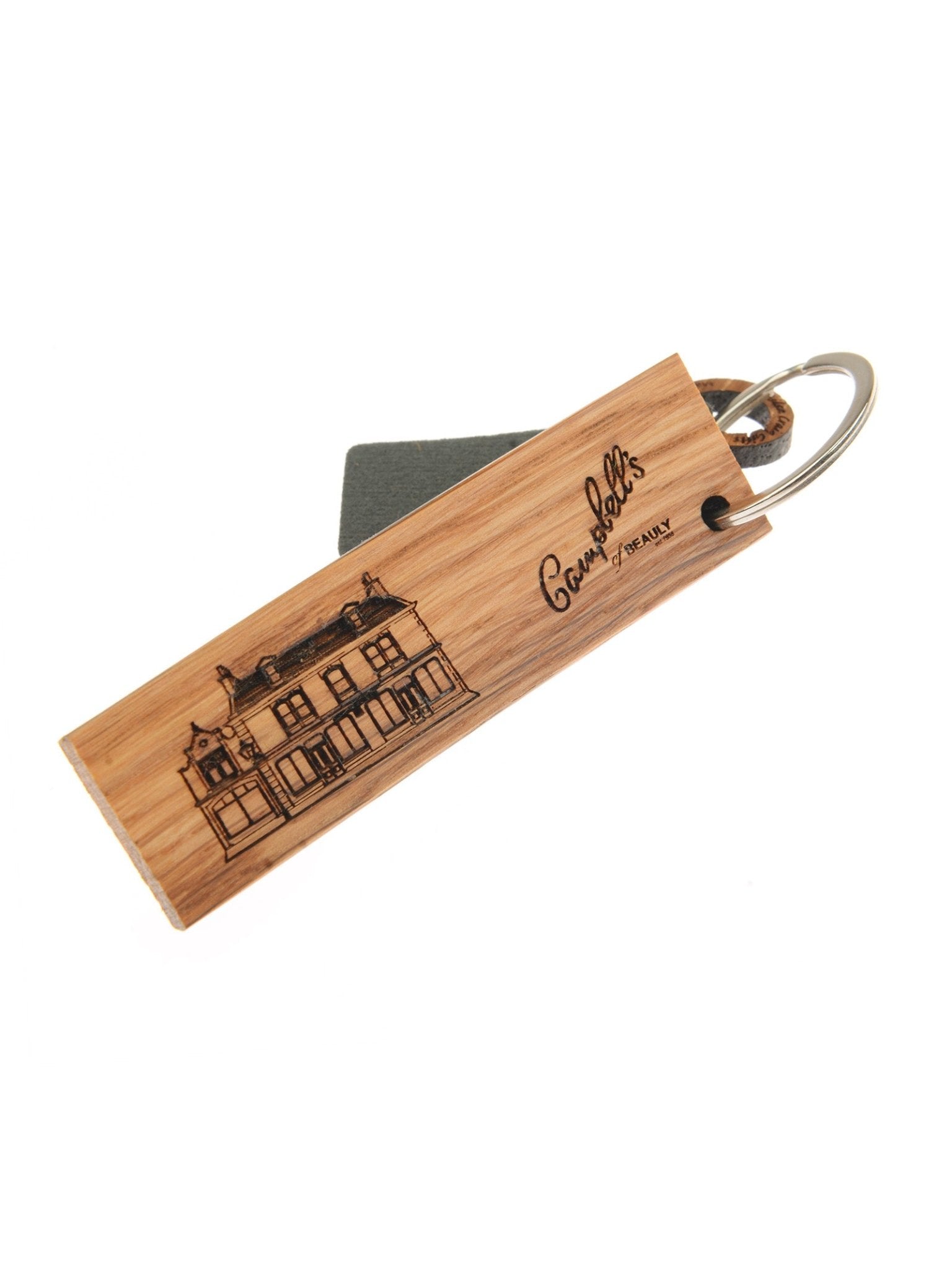 The Whisky Barrel Keyring (Beauly Store) by Campbell's of Beauly features a rectangular oak piece engraved with a building and brand name, celebrating Highland heritage. It includes a metal ring and a small grey tag.