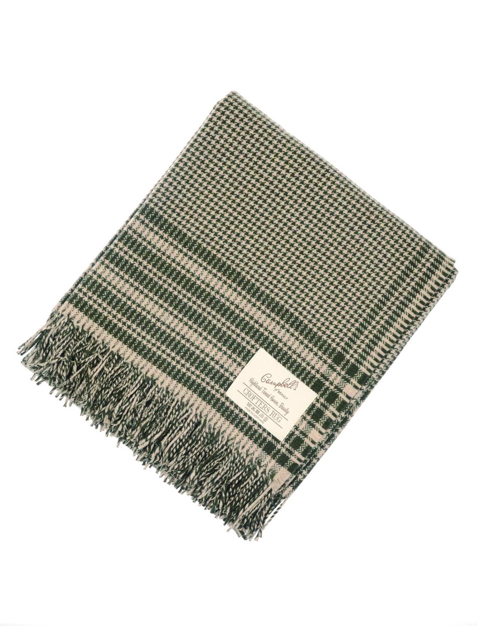 The Campbell's of Beauly Crofters Blanket in green and beige showcases a classic houndstooth pattern, fringed edges, and a white label—ideal for bringing a cozy, country vibe to your space.