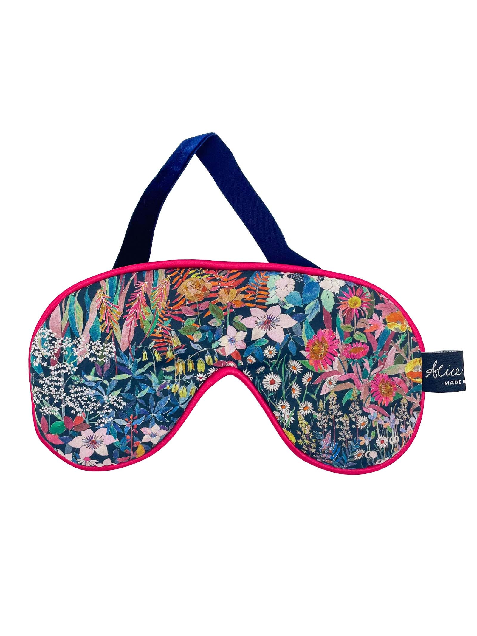 The Liberty Print Eye Mask by Alice Caroline features a vibrant floral pattern, dark blue strap, and pink trim.