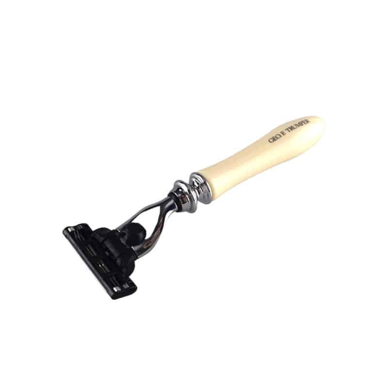 A Geo. F. Trumper Simulated Ivory Mach 3 Razor Handle, cream-colored with a black razor head, features the angled text COLT TRUMAN on the handle.
