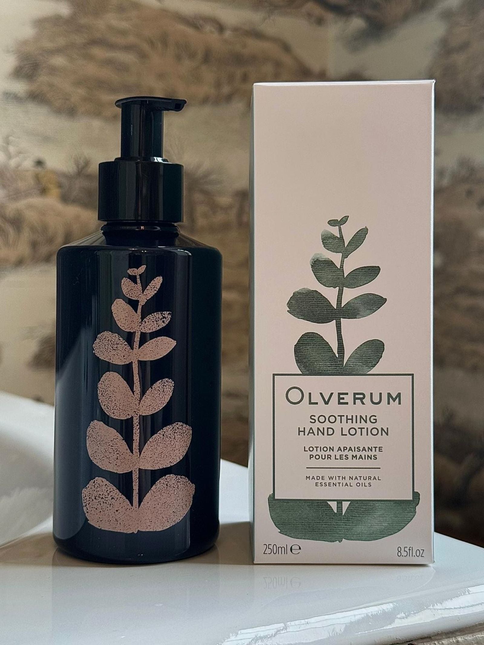 The OLVERUM Soothing Hand Lotion comes in a 250ml dark pump bottle with a matching box featuring a leaf design. This vegan lotion is crafted with natural essential oils for gentle, nourishing hand care.