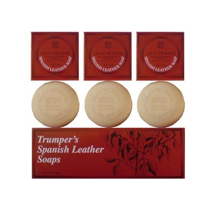 Three round beige Spanish Leather Hand Soaps by Geo. F. Trumper, displayed with three matching red square boxes and a rectangular red box featuring a leaf illustration—an elegant set of luxury guest soaps.